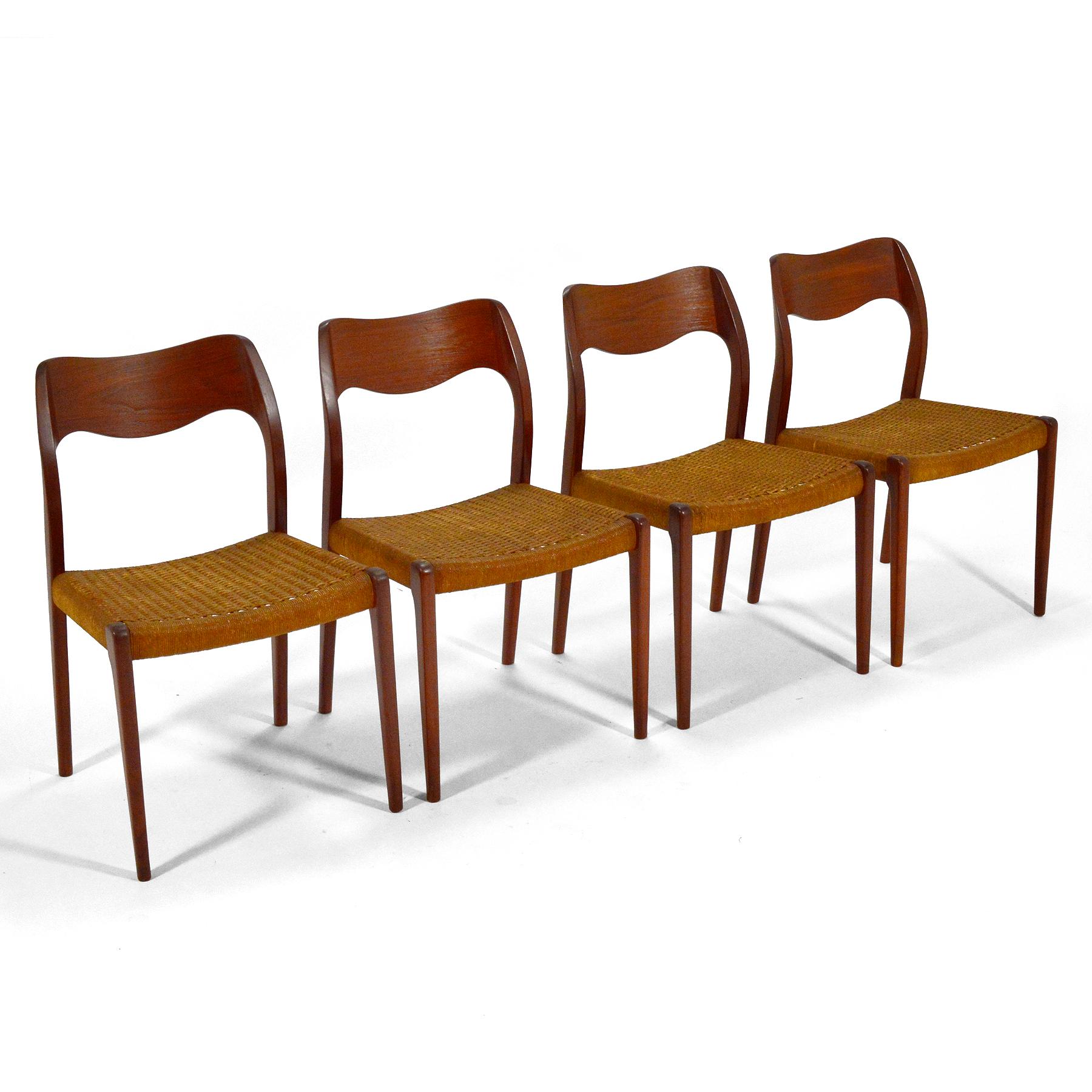 A handsome set of four model 71 dining chairs designed by Niels O. Møller and made by J.L. Møllers Møbelfabrik. The sculptural teak frames and woven paper cord seats have a beautiful patina from years of age and use.