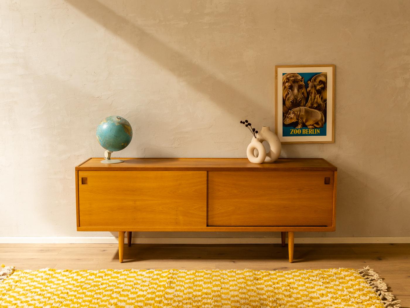 Rare sideboard from the 1950s. Model 20 by Niels O. Møller for his own furniture production company JL Møllers Møbelfabrik. Corpus in oak veneer with two sliding doors, four internal solid wood drawers, two shelves and time-typical cigar-shaped