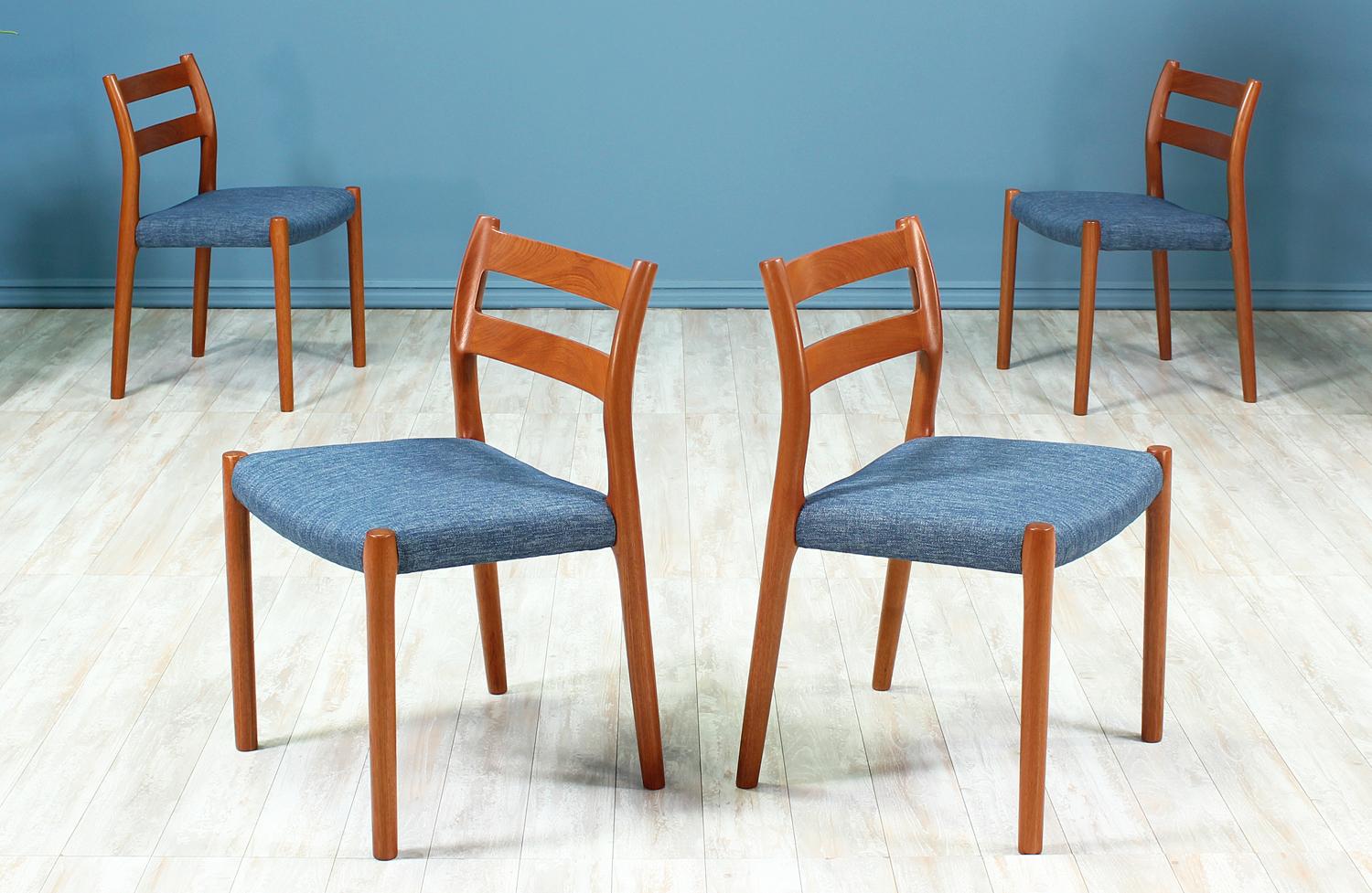 Set of four dining chairs designed by Niels O. Møller for J.L. Møllers in Denmark circa 1970’s. All four chairs are comprised of solid teak wood with new blue tweed upholstery covering the seats. Though mostly machine-made, this chair has a