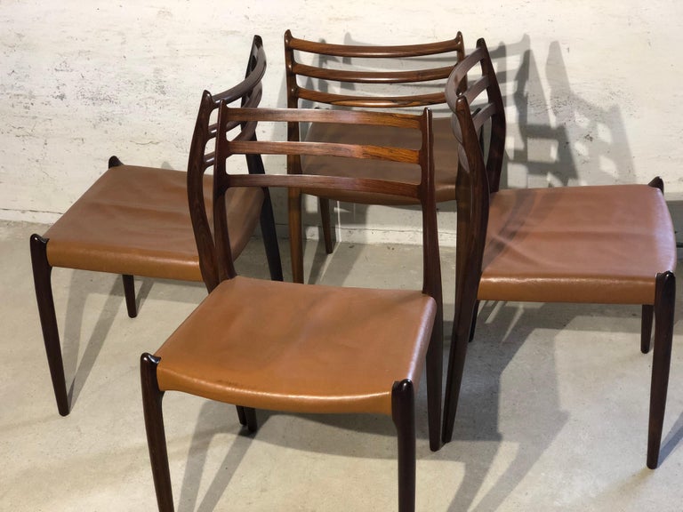 Niels O. Møller No. 78, set of 4 rosewood dining chairs. The wooden frame has stunning details, upholstery in light brown leather. They are in a very good vintage condition,.