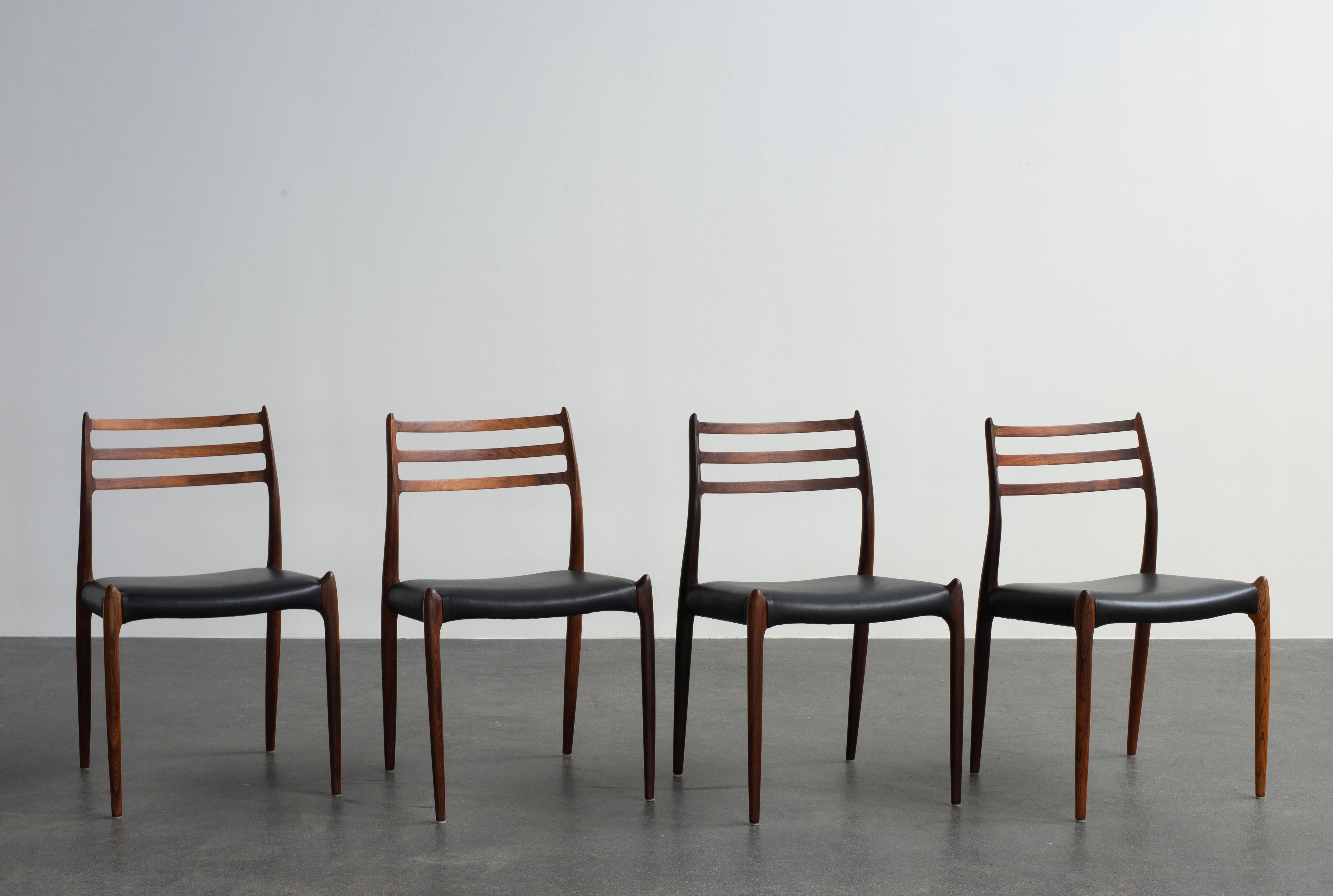 Niels O. Møller Satz von vier Stühlen aus Palisanderholz, Sitze mit schwarzem Leder gepolstert. Hergestellt von J. L. Møller, Dänemark.