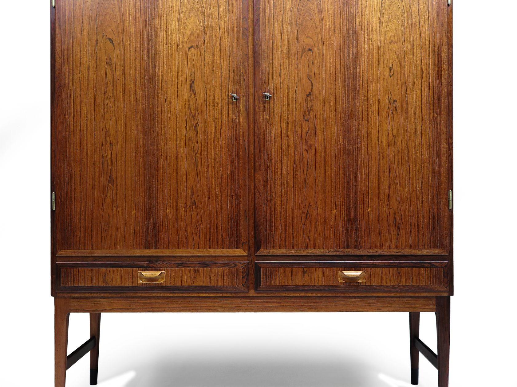 Armadio in palissandro brasiliano perfettamente restaurato progettato da Niels Otto Møller per J.L. Møller Møbelfabrik, 1958, Danimarca. Caratterizzato da una splendida venatura di palissandro abbinata al libro, il mobile è dotato di due ante con