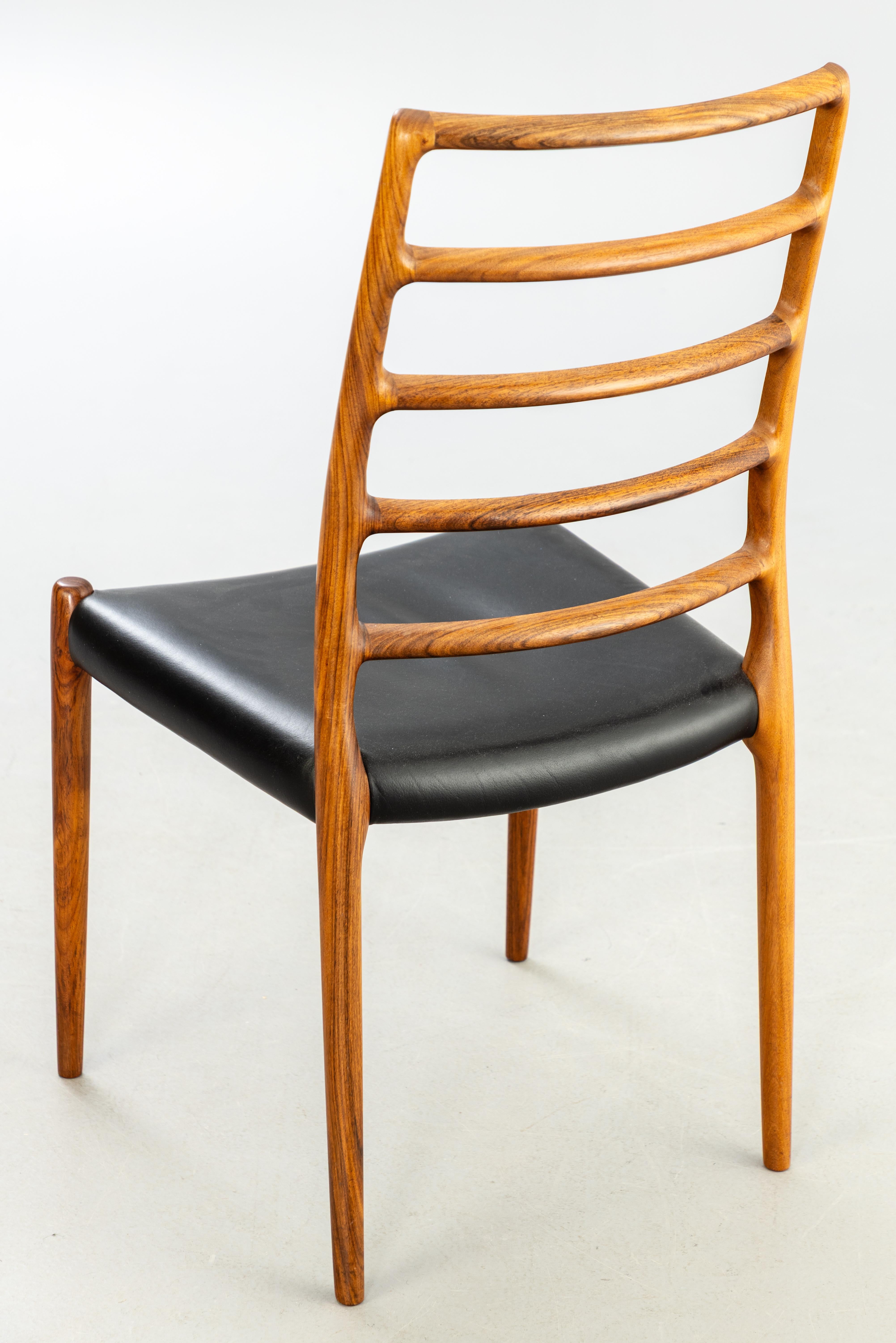 Chaise Niels Otto Moller modèle iconique 82   produit au Danemark  par I.L.A. Moller Mobelfabrik vers 1960 . Ensemble de 6 pièces Fabriqué en bois de rose massif du Honduras au grain luxueux et exotique. Sièges recouverts de cuir noir aniline.
