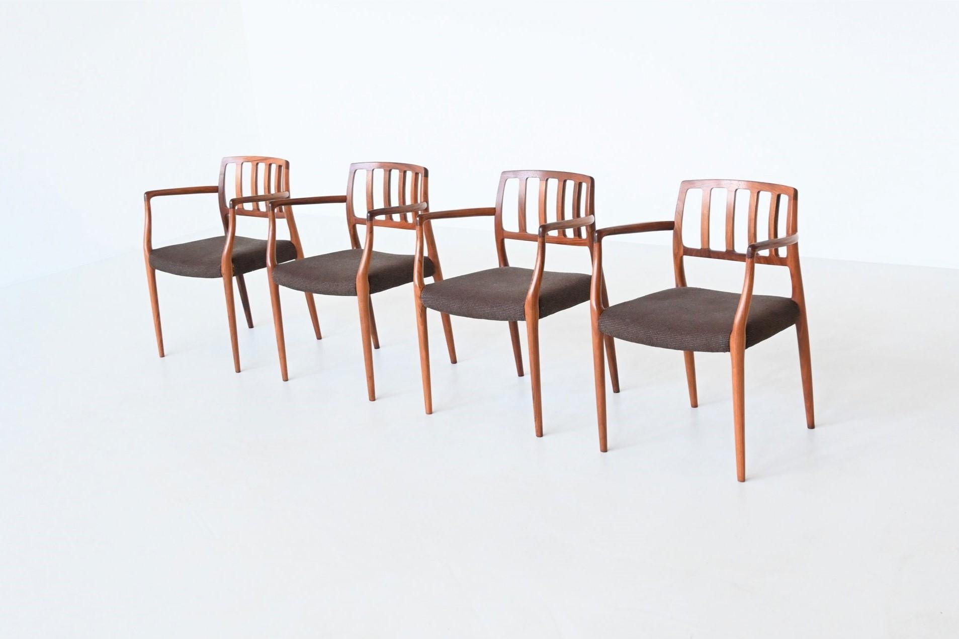 Beautiful shaped and rare set of four armchairs model 66 designed by Niels Otto Møller and manufactured by J.L. Møller Mobelfabrik, Denmark 1974. These sculptural dining chairs are made of solid amazingly grained walnut and the seats are upholstered