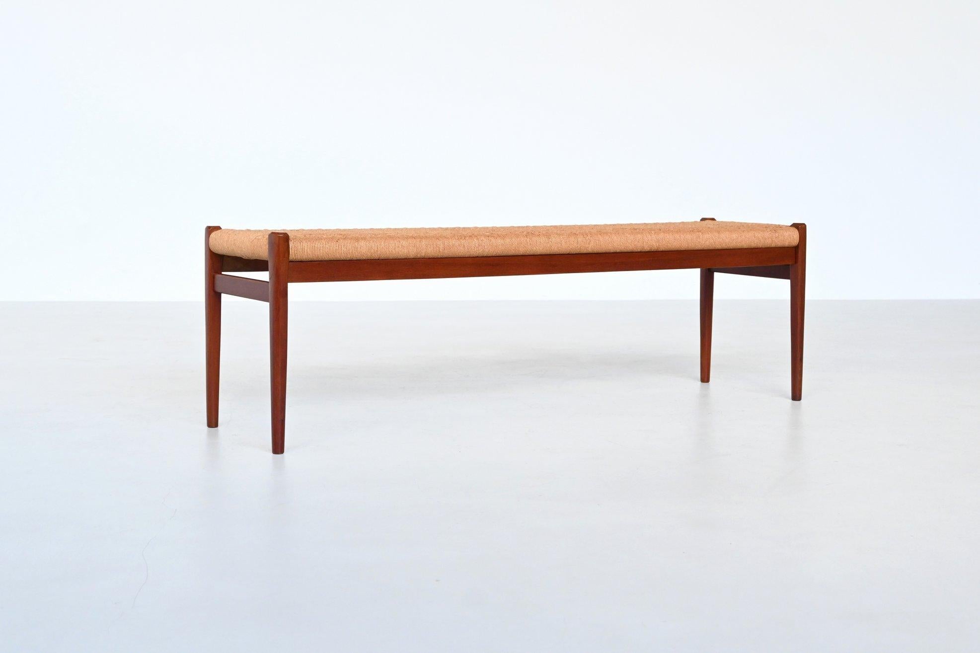 Iconic bench model 63 designed by Niels Otto Møller and manufactured by J.L. Møller Mobelfabrik, Denmark 1960. This beautiful shaped bench is made of solid teak tapered wood and the seat is upholstered with original woven paper cord. The wood has a