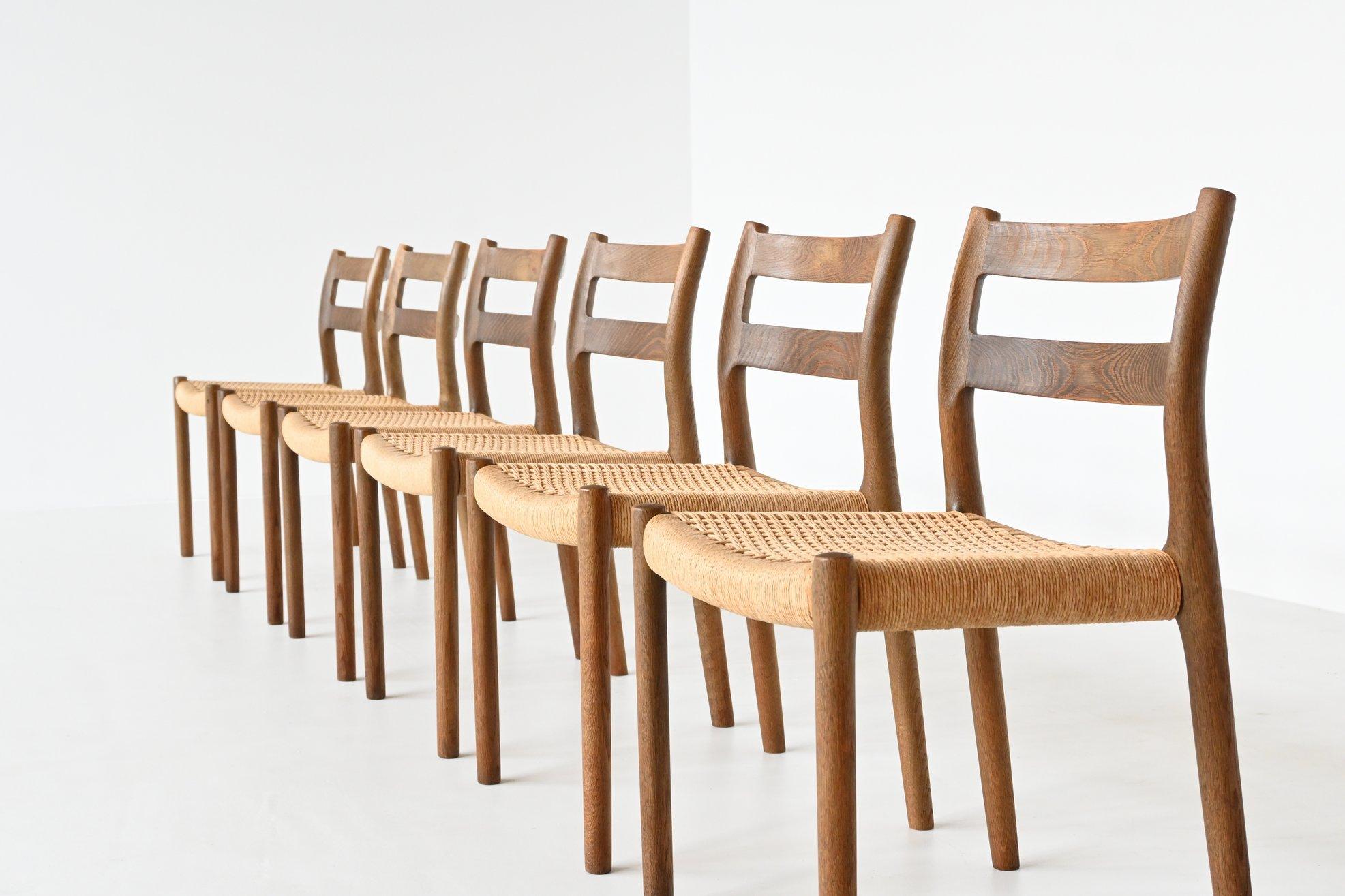 Very nice set of six dining chairs model 84 designed by Niels Otto Møller and manufactured by J.L. Møller Mobelfabrik, Denmark 1960. They are made of solid stained oak wood and the seats are upholstered with paper cord. These well-crafted chairs are