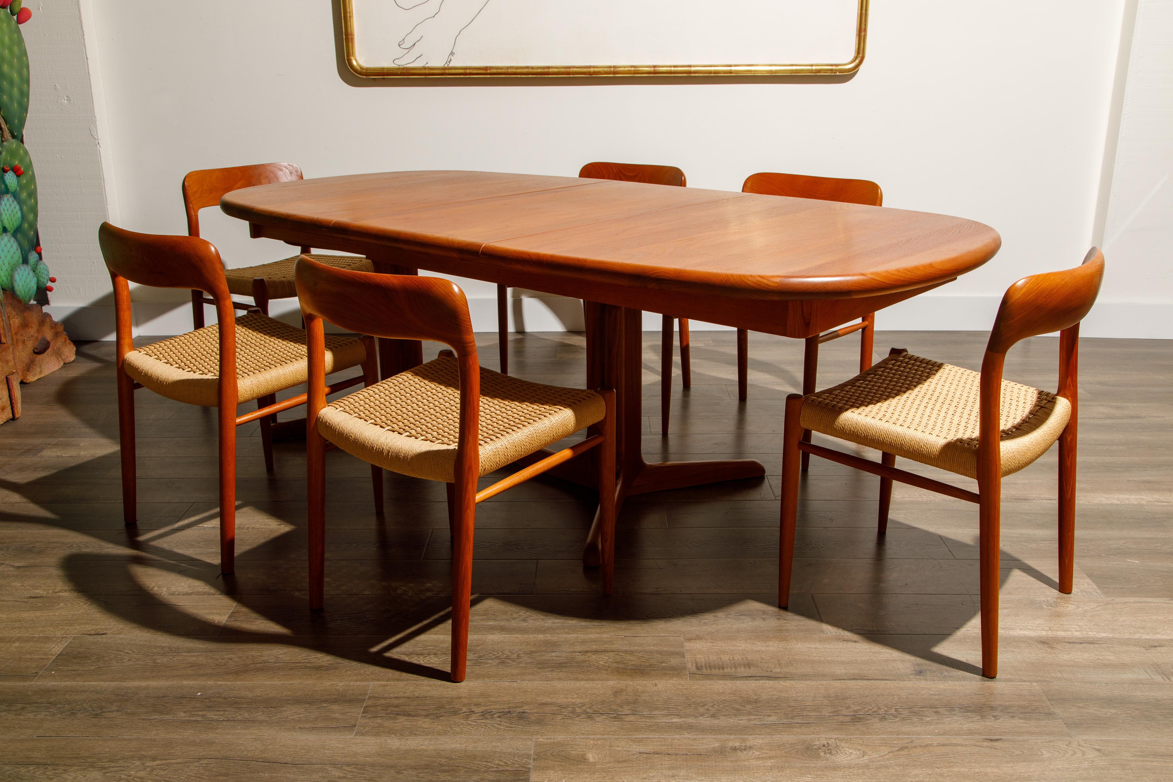 This incredible teak dining set by Niels Otto Møller for J.L. Møllers Møbelfabrik includes six (6) Model 75 papercord dining chairs and one (1) heavy solid teak expandable dining table which includes two leaves and can seat up to 10 people when