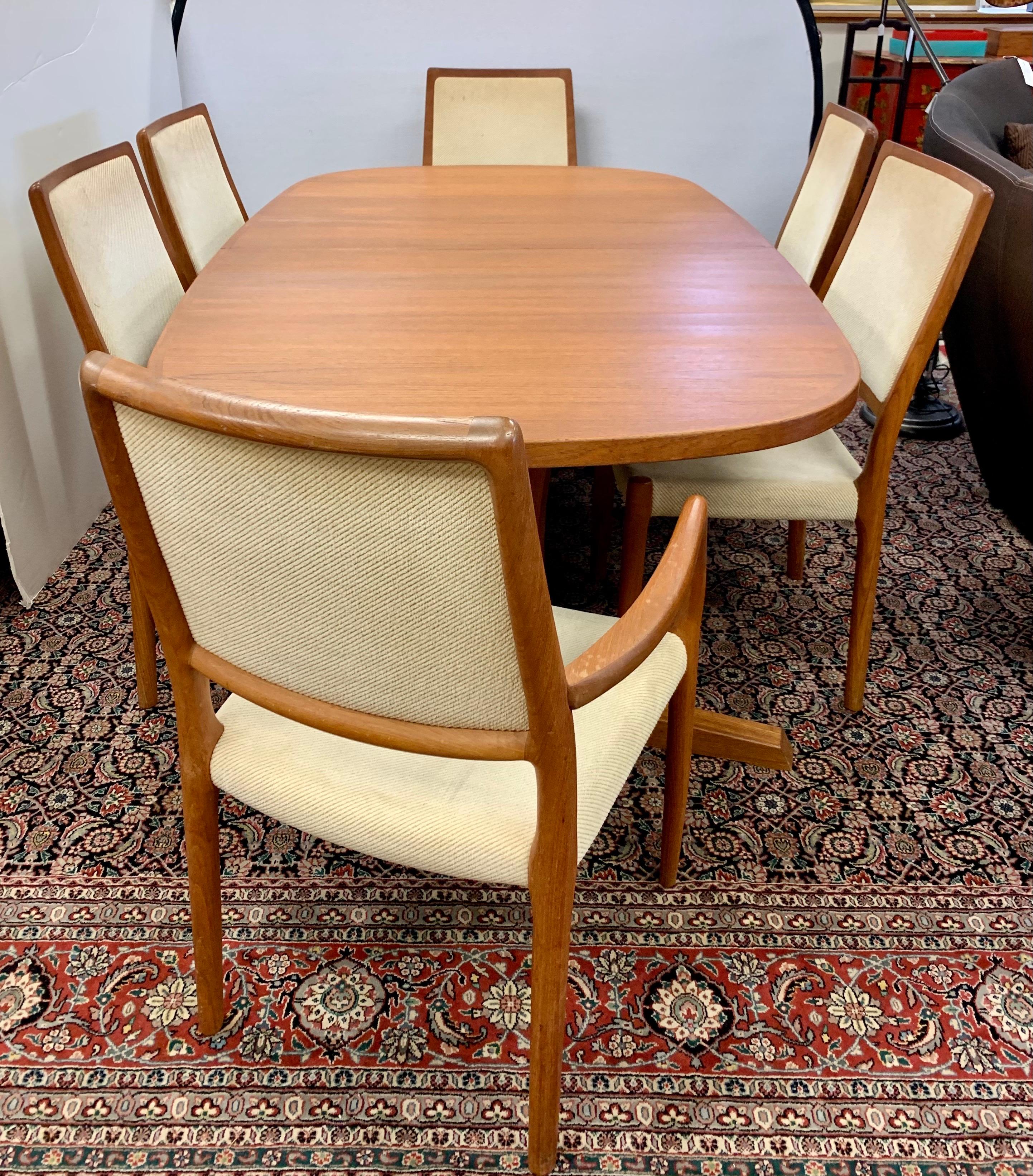 A magnificent original dining set of six chairs and matching table by Danish designer Niels Otto Møller, and manufactured by JL Møllers Møbelfabrik featuring frames made of solid teak and seating made of original neutral upholstered fabric. Why not