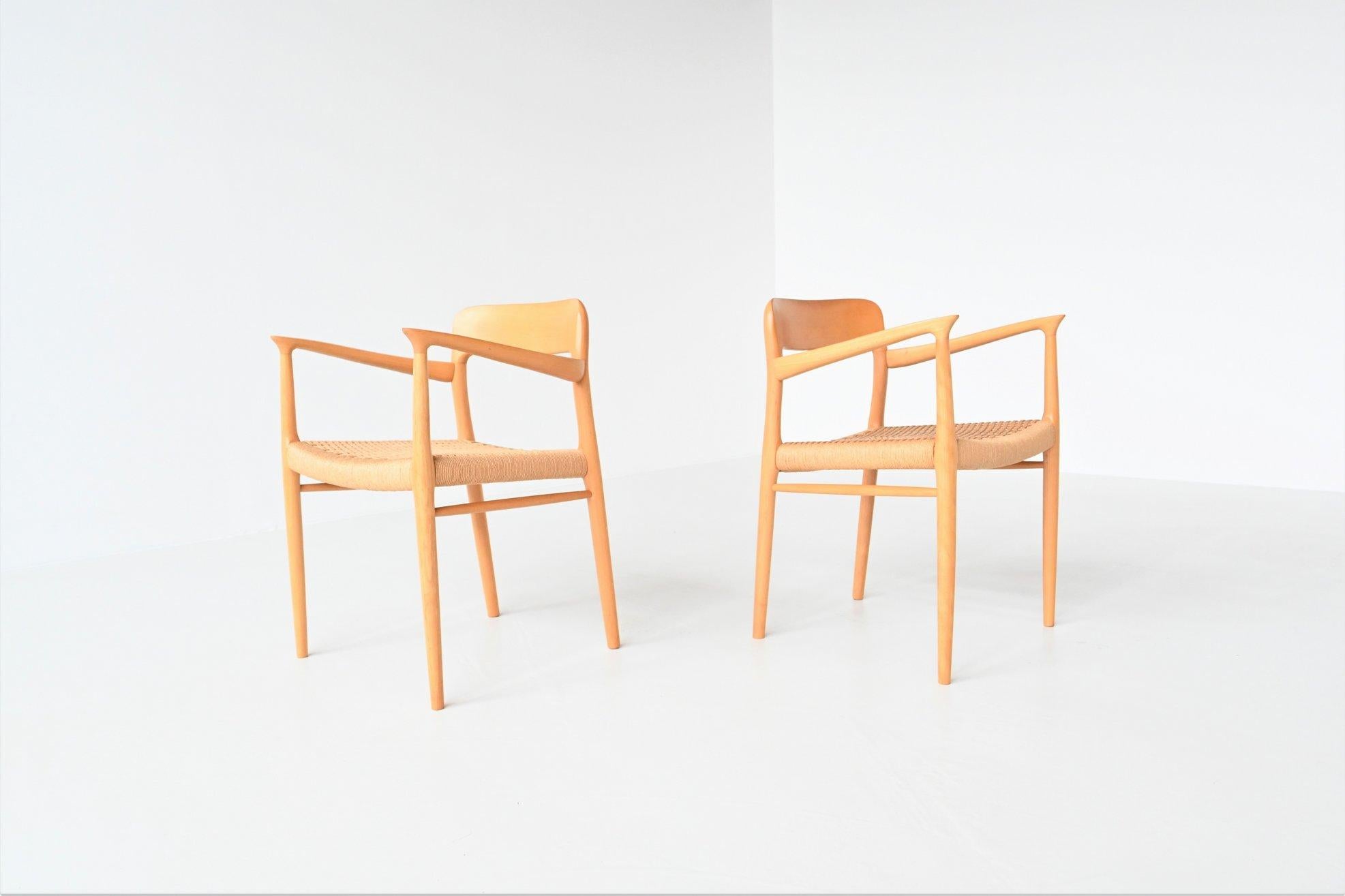 Beautiful shaped pair of armchairs model 56 designed by Niels Otto Møller and manufactured by J.L. Møller Mobelfabrik, Denmark 1954. These iconic dining chairs are made of solid beech wood and have original papercord seats. The back legs are