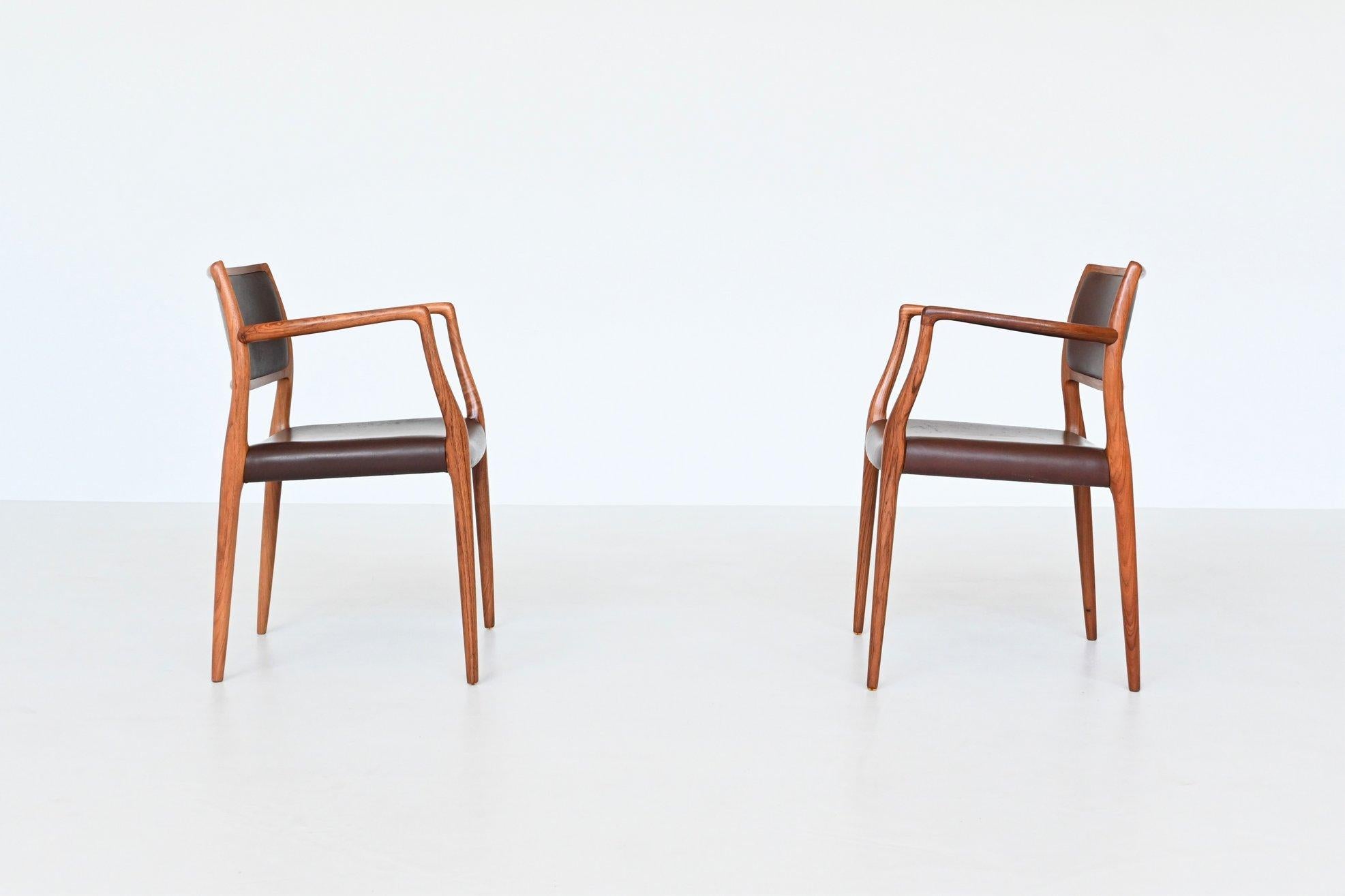 Beautiful shaped pair of armchairs model 65 designed by Niels Otto Møller and manufactured by J.L. Møller Mobelfabrik, Denmark 1968. These sculptural and elegant dining chairs are made of solid amazingly grained rosewood. The seats are upholstered