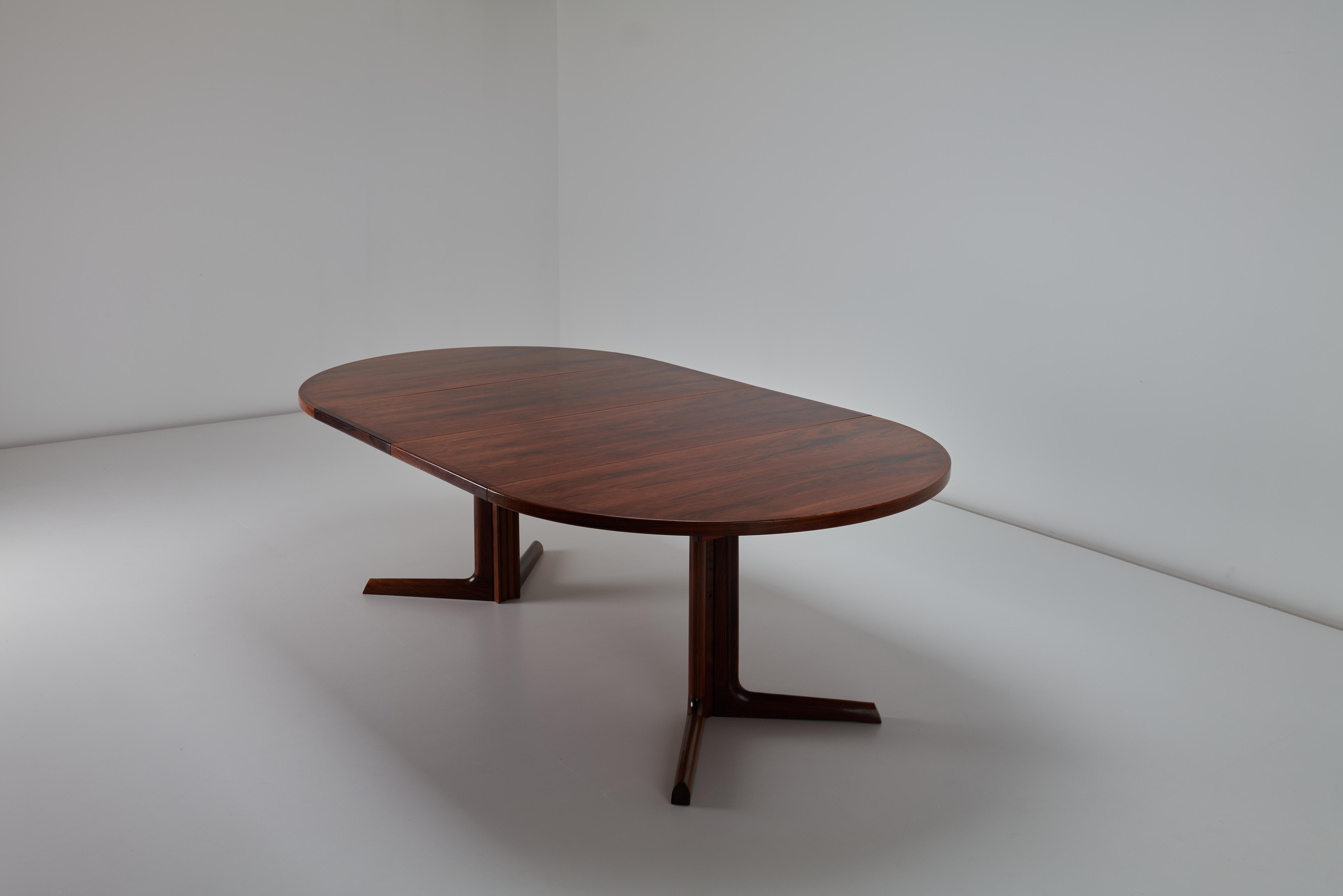 For sale is a stunning Niels O. Møller dining table, expertly crafted by Gudme Møbelfabrik in the 1970s. This exceptional piece features a bookmatched rosewood veneer top that highlights the rich, natural grain and deep, warm hues of the wood. The