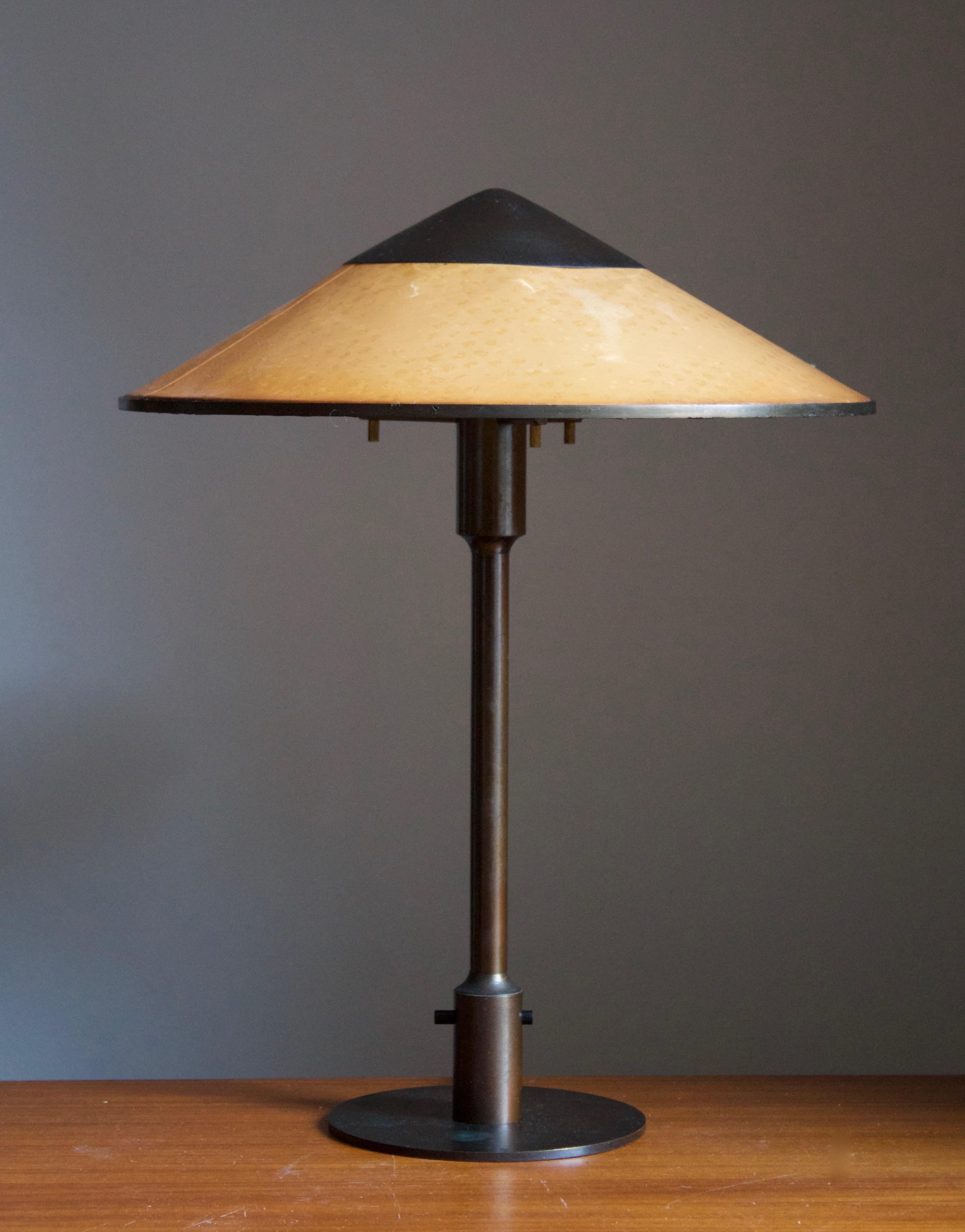 A rare and early table lamp / desk light. Designed by Niels Rasmussen Thykier, Denmark, 1930s. Features a break-through switch typical to early production examples.

In patinated brass and waxed paper screen.


