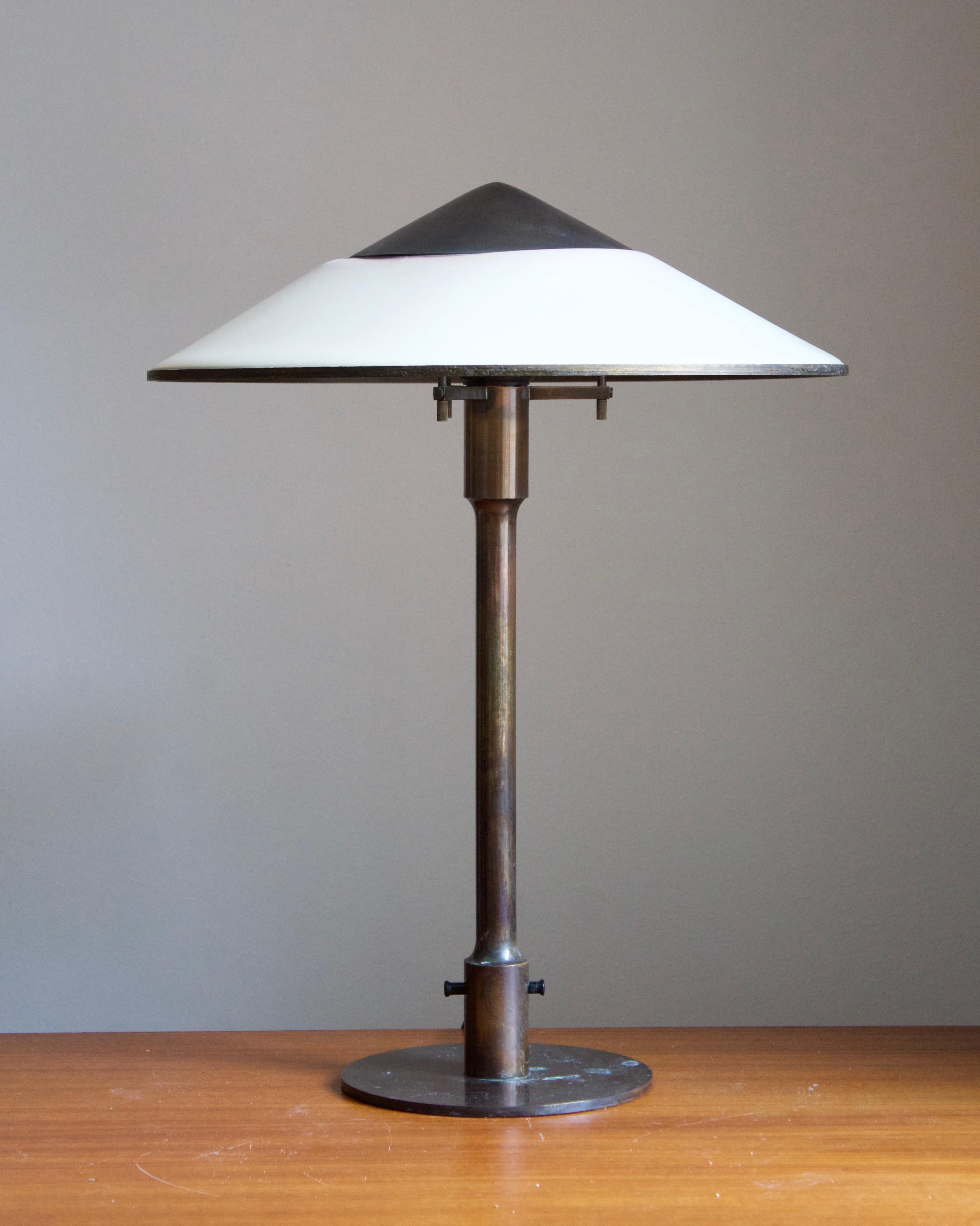 A rare and early table lamp / desk light. Designed by Niels Rasmussen Thykier, Denmark, 1930s. Features a break-through switch typical to early production examples.

In patinated brass and waxed paper screen.

  