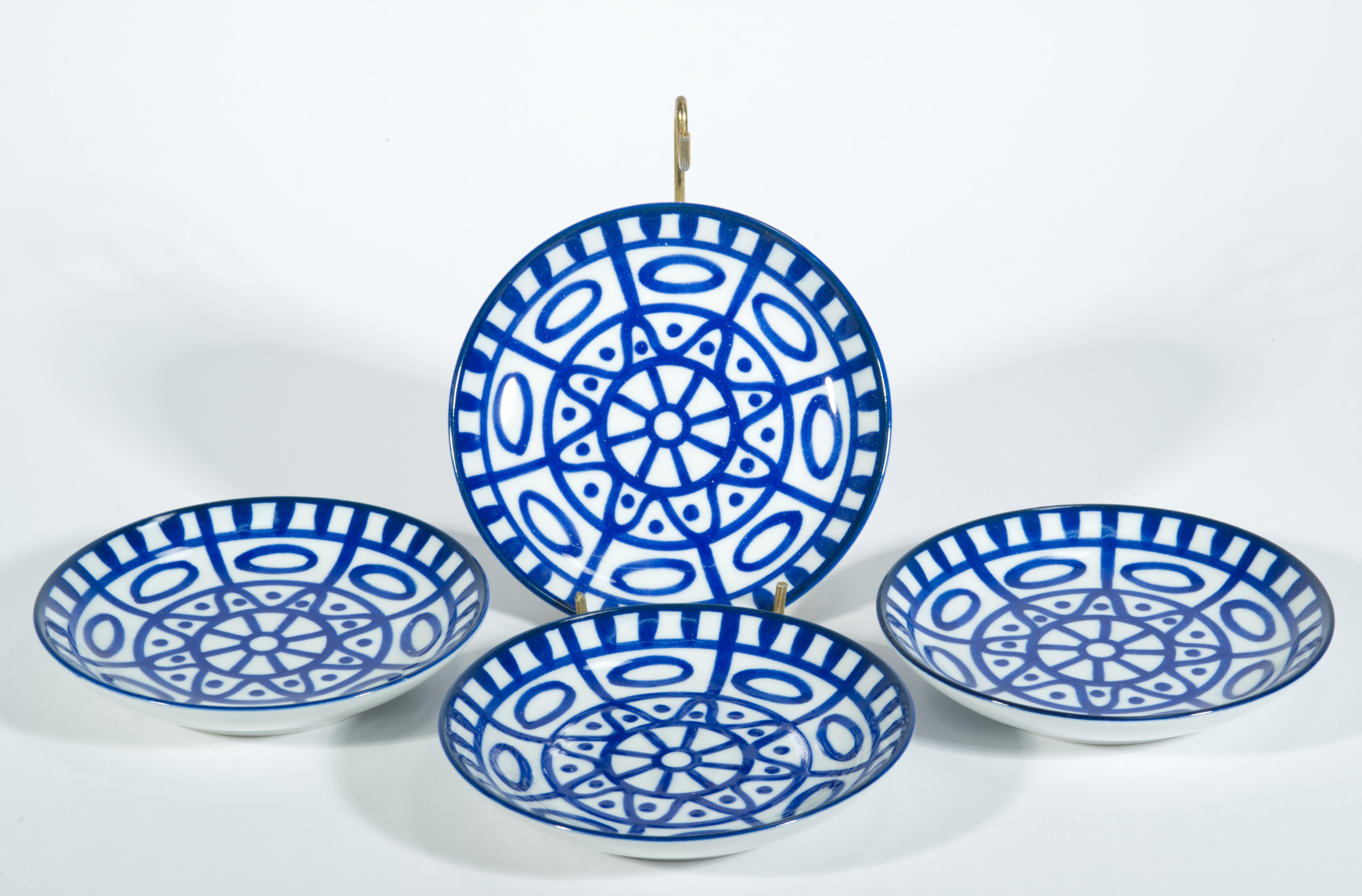 Striking vintage porcelain coasters feature blue geometric pattern on bright white porcelain background, creating an abstract decor in distinctive Scandinavian blue and white colors. Arabesque series was created by Niels Refsgaard for Dansk; it is