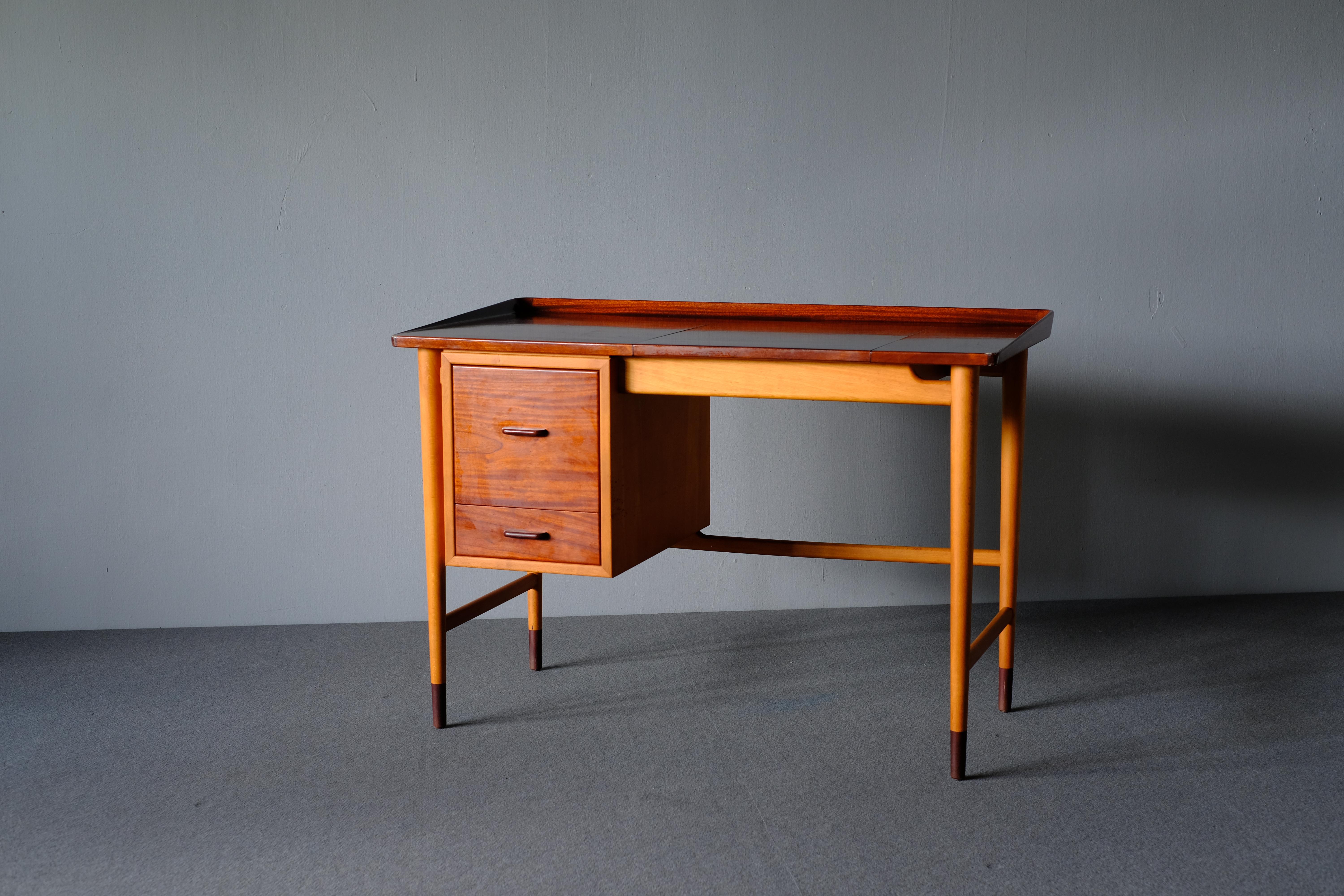 Really charming dressing table. Made by cabinetmaker Niels Vodder in the 1940s. It has his hallmark of pieces being formally elegant yet modest in structure. It is fashioned in beech with the top, drawer fronts and shoes in mahogany. The flip up top