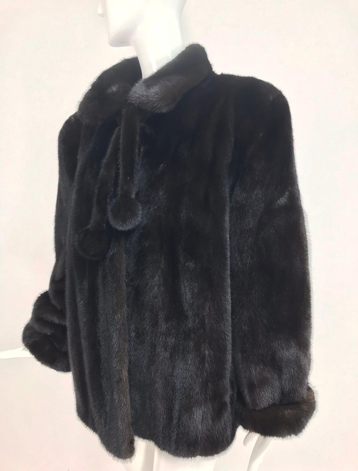 Nieman Marcus black mink fur jacket with pom pom ties from Nieman Marcus. This gorgeous jacket is in excellent condition, dark glossy fur is supple with no issues. The jacket has long sleeves that are slightly full with 2 inch turn back cuffs. Round