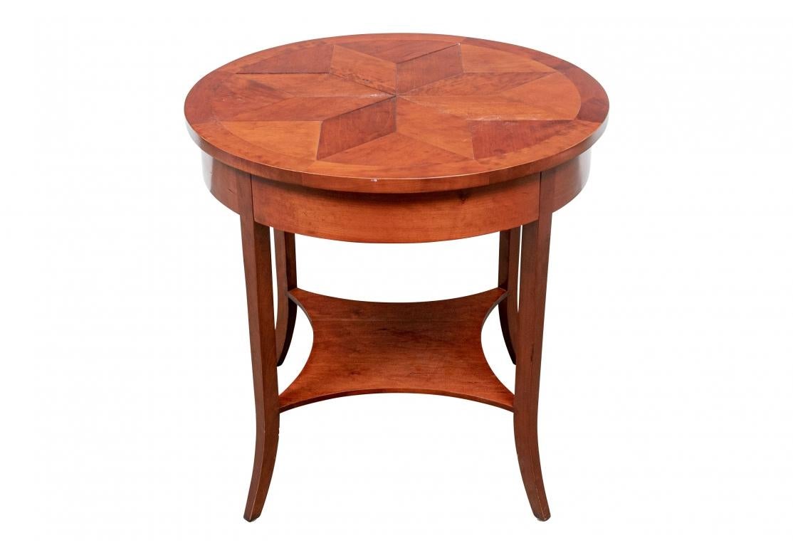 Round parquet side table by Niermann Weeks with inlaid star motif, frieze drawer and four splayed legs conjoined with a lower tier. Niermann Weeks metal label attached inside of the drawer. 

Dimensions: 30