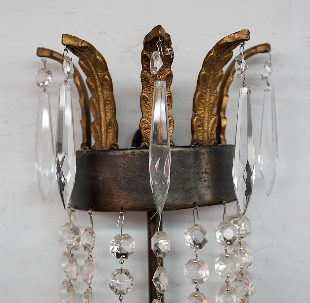 An elegant iron and crystal wall sconce or lantern by Niermann Weeks. The sconce is made of solid metal and crystals in a timeless Empire style fashion. The sconce features a plume crown at top and is embellished with faceted crystal beads while the