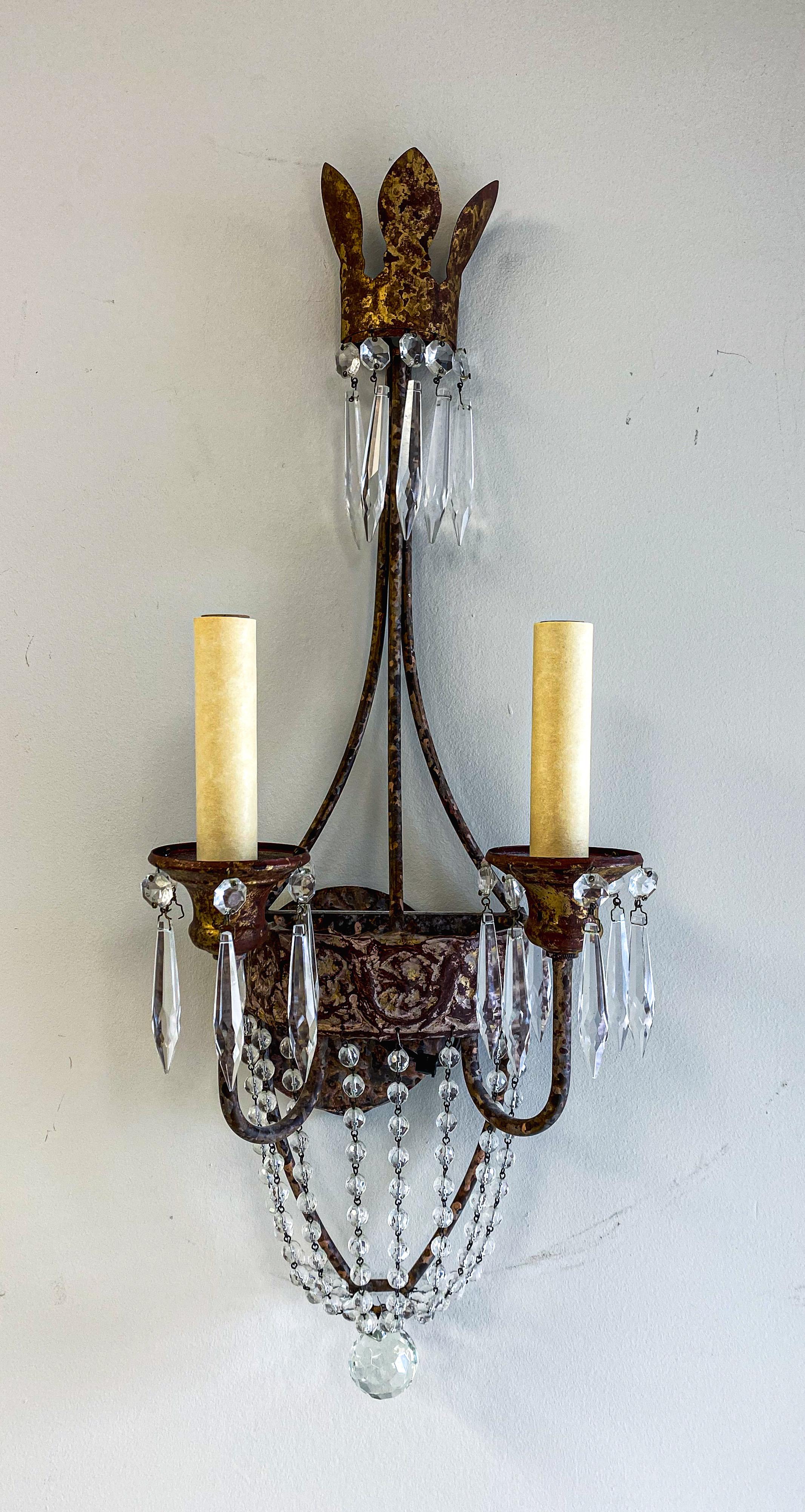 An exquisite pair of Niermann Weeks Italian style Neapolitan sconces. Each sconce features a leaf crown-designed top and embellished with beaded swags and two tiers of crystal prisms terminating in a faceted crystal ball.  The quality sconces are