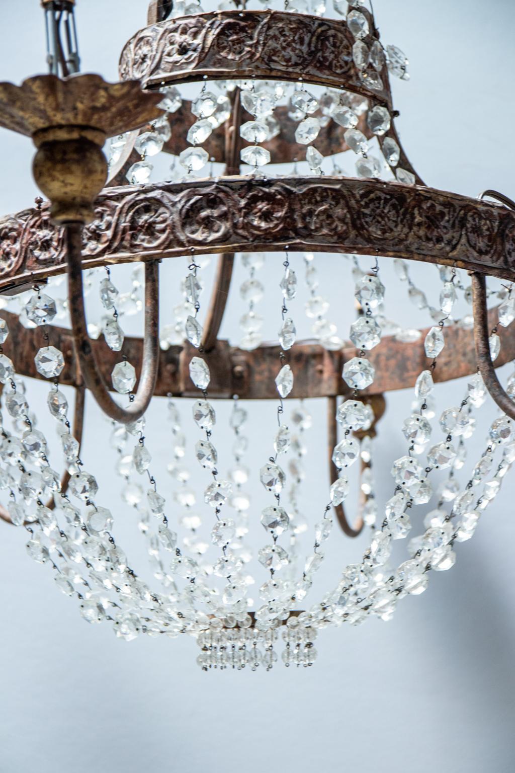 Circa late 20th century chandelier by Niermann Weeks accented with circular tin bands of repoussé guilloche trim and swags of crystal bead strands. The six arm chandelier is also constructed with tin scalloped trim bobeches . Please note of wear
