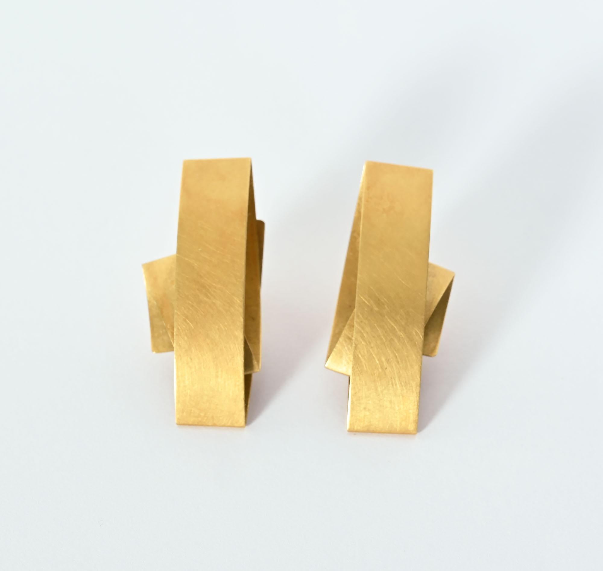 Modernist earrings by German jeweler, Niessing. The irregular folded gold has something of the look of origami, The metal has a soft brushed finish. Backs are posts. The earrings measure 3/8 inch wide and 1 1/2 inches long.