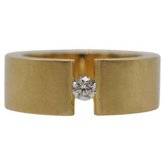 Niessing tension ring in 18k yellow gold with a brilliant