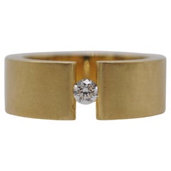 Niessing tension ring in 18k yellow gold with a brilliant