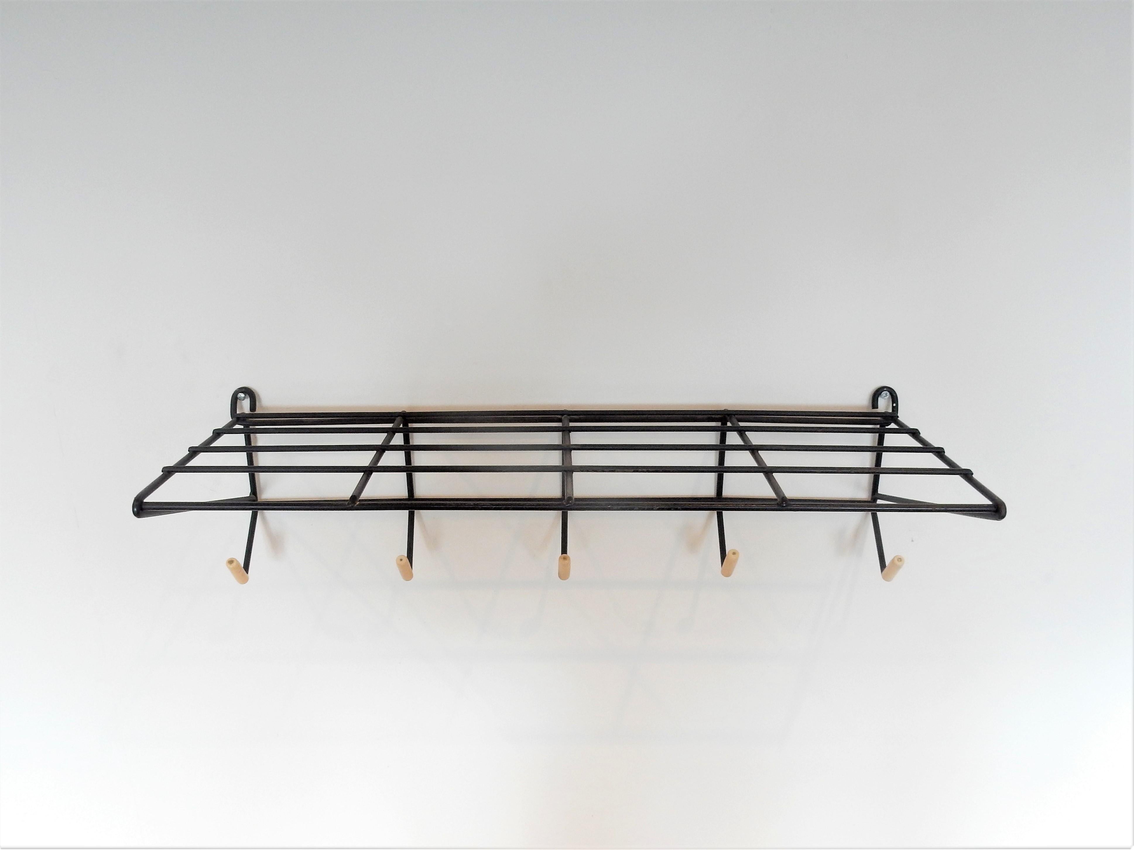 This fabulous coat rack was designed by Friso Kramer for 't Spectrum in 1954. The designs of Friso Kramer are much sought after. This particular one is of black lacquered metal with white plastic knobs on the hooks. A solid designed construction