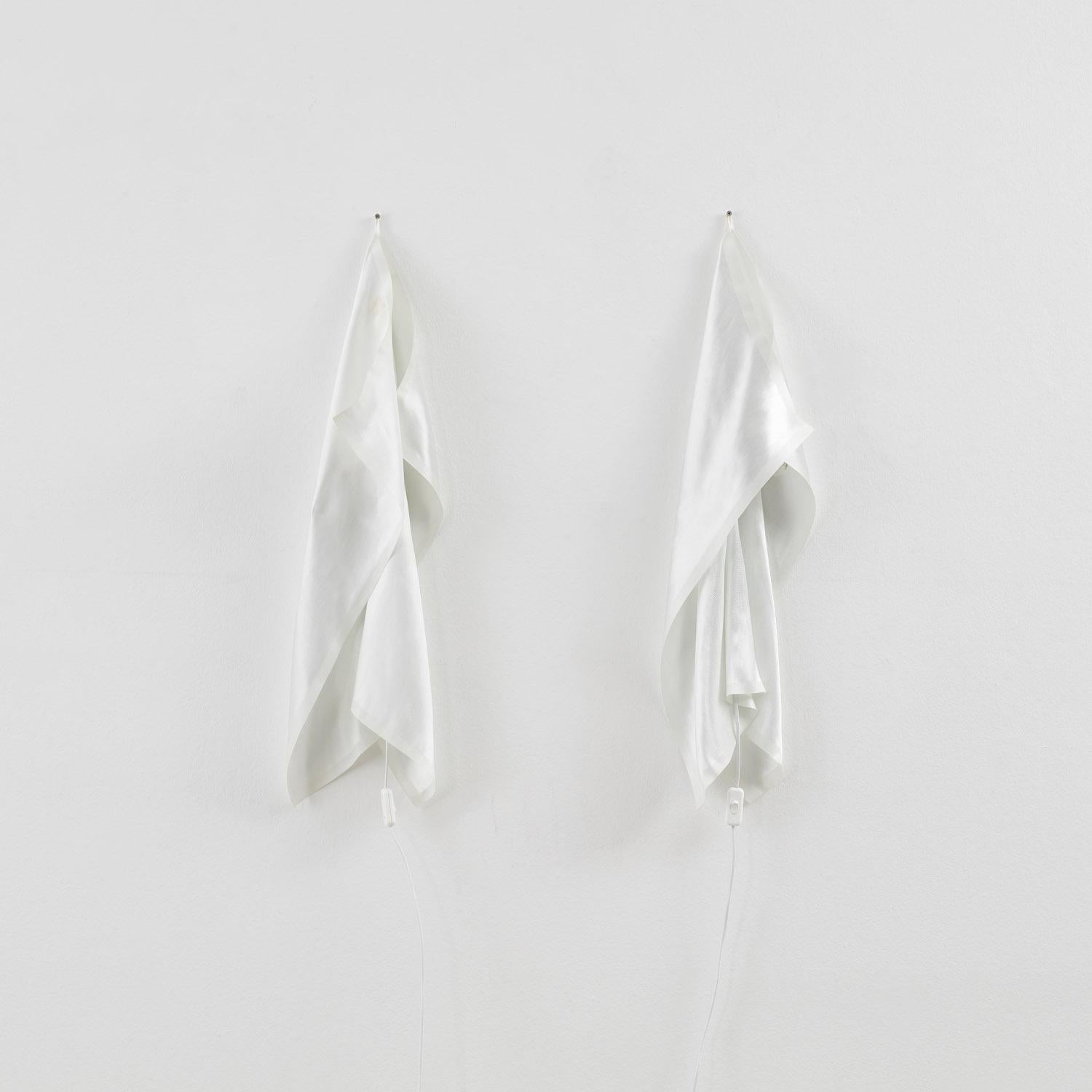 Los apliques de pared Delight, una interpretación lúdica del humilde paño de cocina, fueron creados para el fabricante de iluminación Ingo Maurer por los diseñadores holandeses Martijn Wegman y Frans van Nieuwenborg, quienes, tras estudiar en la
