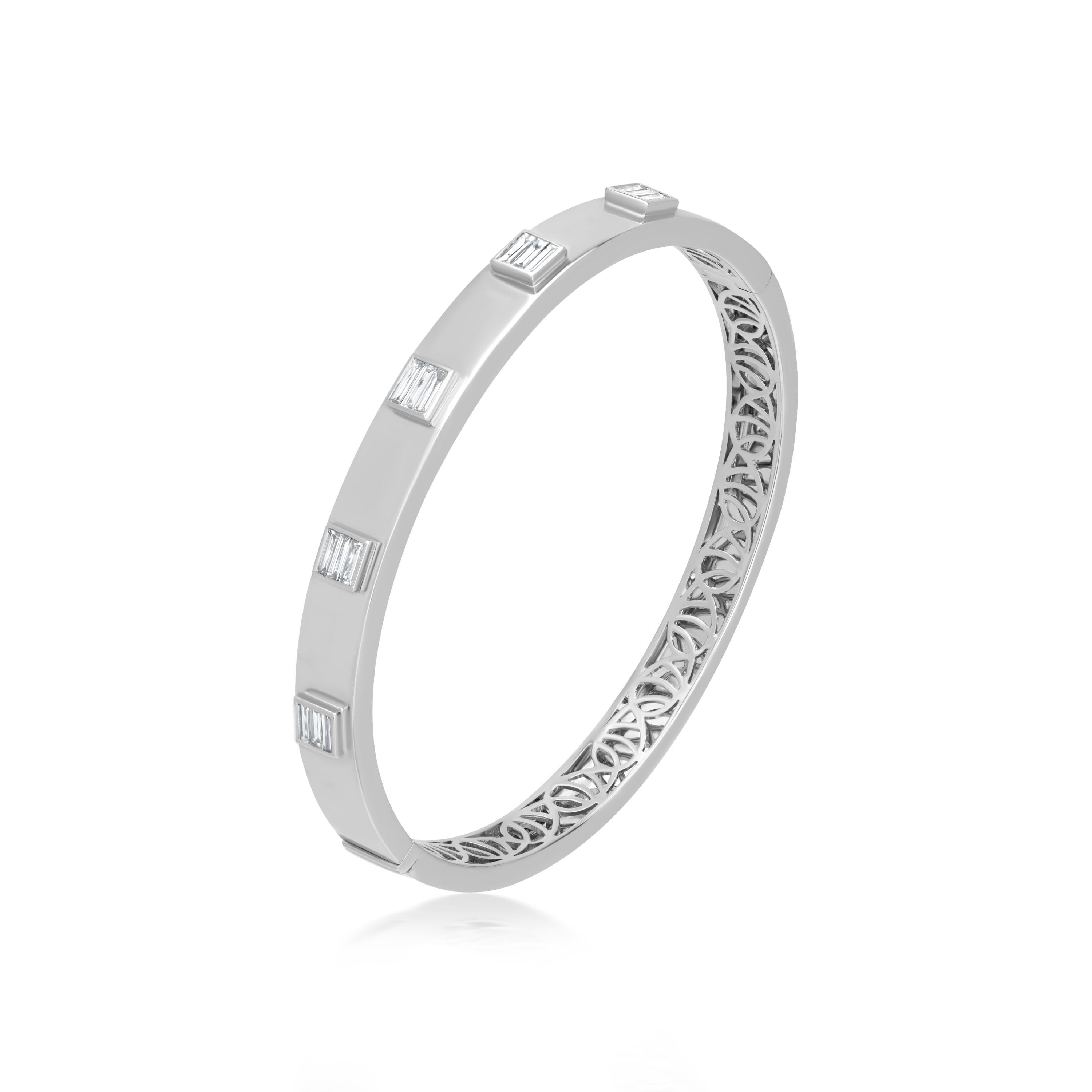 Adorn yourself with this spectacular bangle bracelet 0.66 ct. t.w. bezel set baguette full-cut diamonds alternate on polished 18k white gold. The inner back of the bangle bracelet is further accentuated by curvilinear lattice. Inner Dimension : 50mm