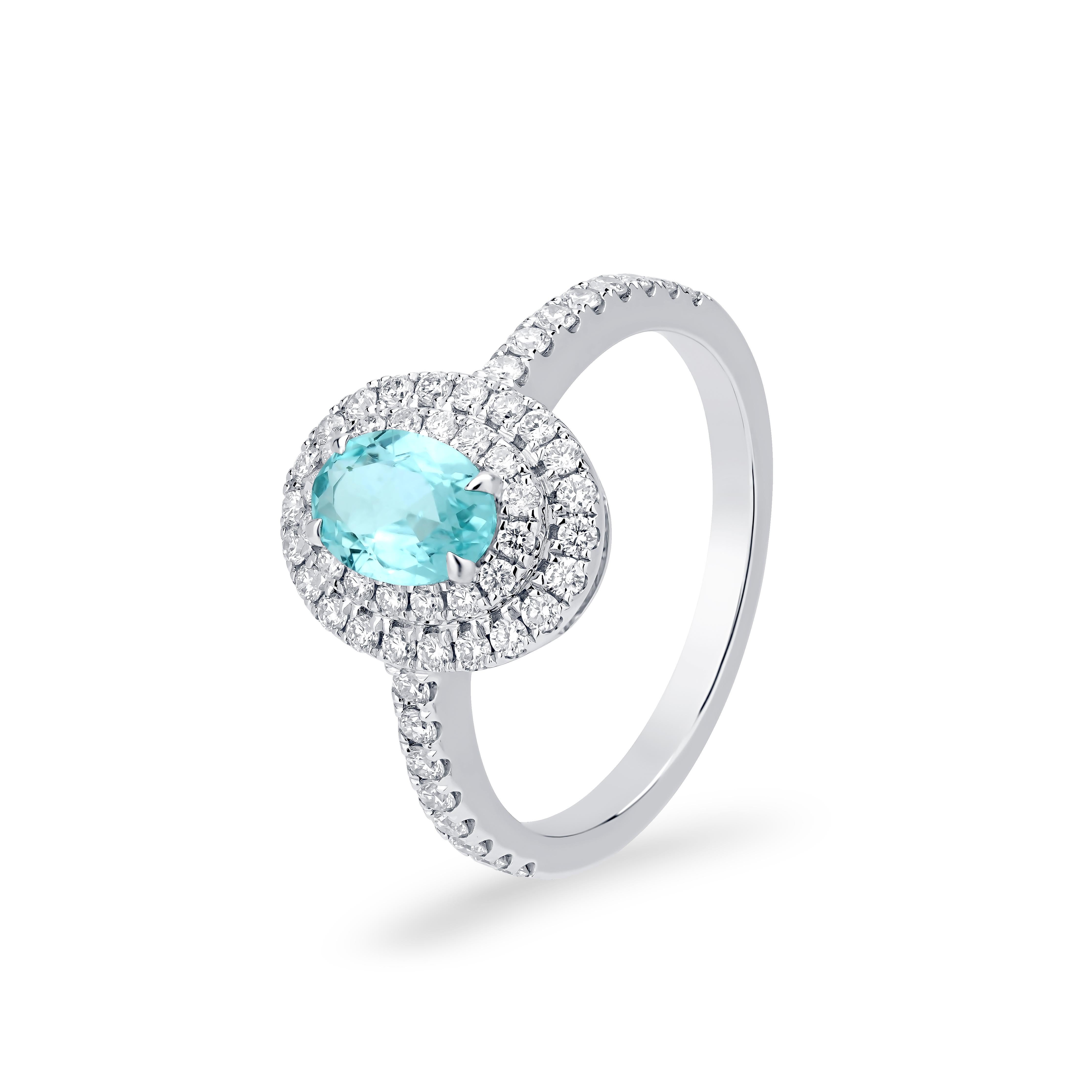 This engagement ring's centerpiece is an oval-shaped Paraiba that is prong-set, surrounded by round brilliant-cut White Diamonds in a micro pave setting. The diamonds weigh 0.53 carats and are SI1 in clarity and GH in color. This ring sparkles on