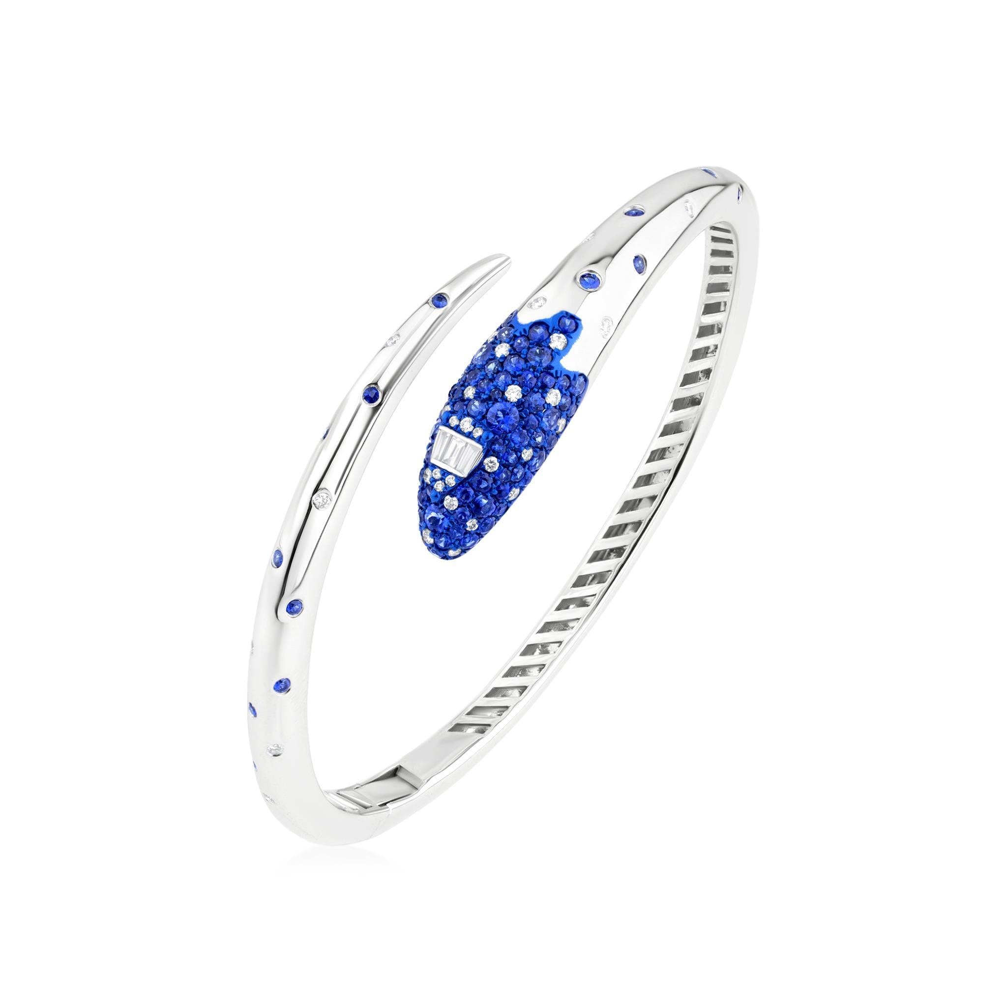 Elevate your style with the exquisite Nigaam 1.92 Cttw. Sapphire and Diamond Serpentine Cuff Bracelet in 18K White Gold and Blue Rhodium. This stunning piece of jewelry is not just an accessory; it's a work of art. 

Crafted with precision and