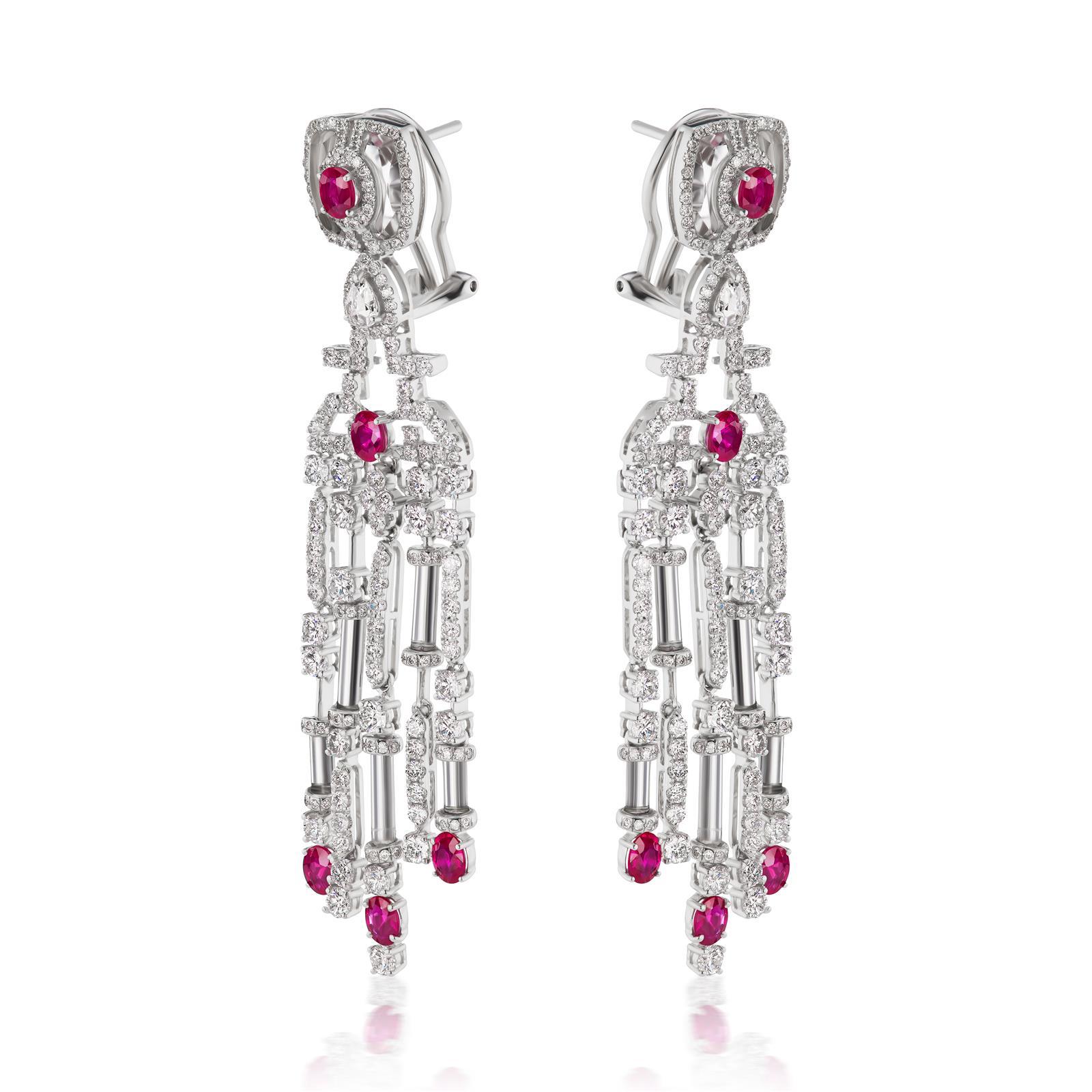 This chandelier Nigaam earring is a beauty to behold. The surmount of the earring features oval cut ruby accentuated by double halo of round diamonds and crystal on either side. The bail of the earring features pear shaped rose cut diamond in pear