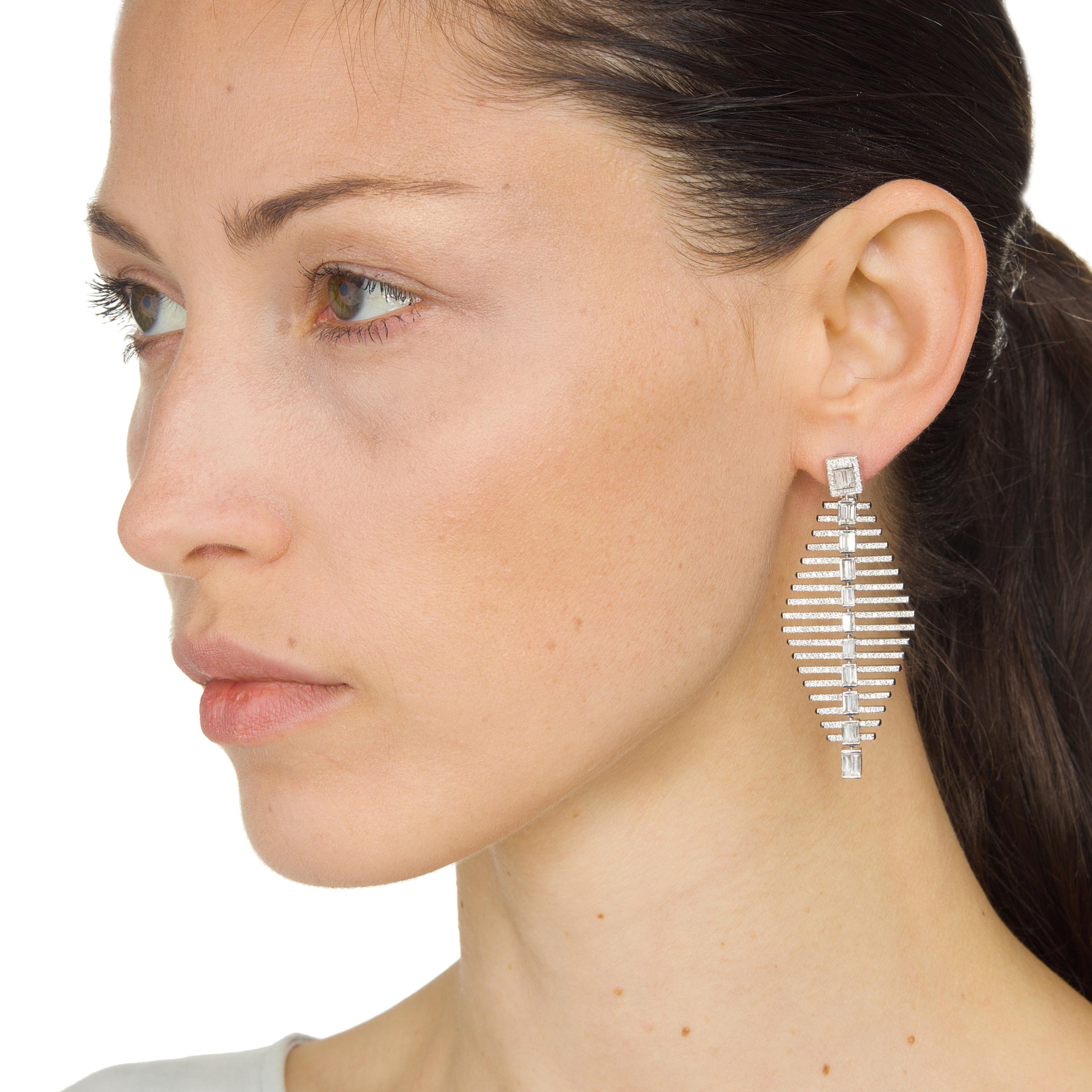 These drop earrings by Nigaam boast graduating baguettes at the center with rows of pave set round diamonds at both sides in continuation patterns set in 18K white gold. Perfect for your special nights and social events.
Please follow the Luxury