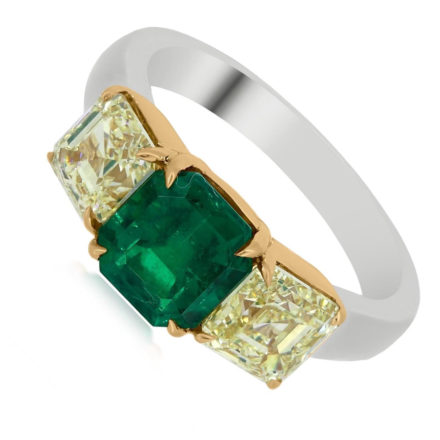 This Nigaam three stone ring in 18k white and yellow gold features an octagon- cut 1.85 carat Emerald Colombian at the center flanked by two 2.49 ct. t.w. square yellow diamonds prong set in yellow gold over the white gold band. 

Please follow the
