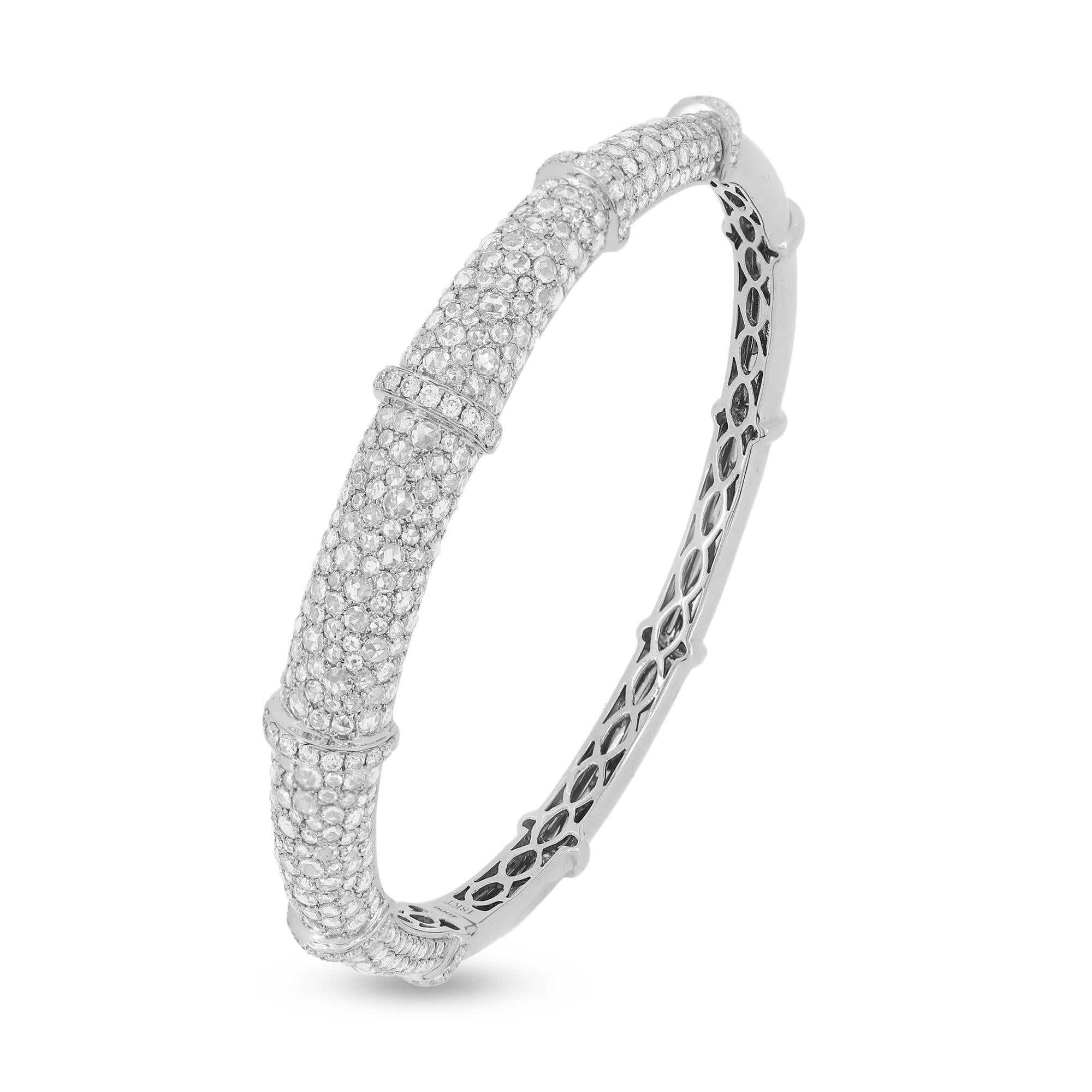 The Nigaam 5.21 Cttw. Round Brilliant Cut Diamond Bangle Bracelet is a stunning piece of jewelry crafted in 18K white gold. The front of the bracelet boasts round pave set diamonds on the body, adding a touch of sparkle and glamour to any outfit.