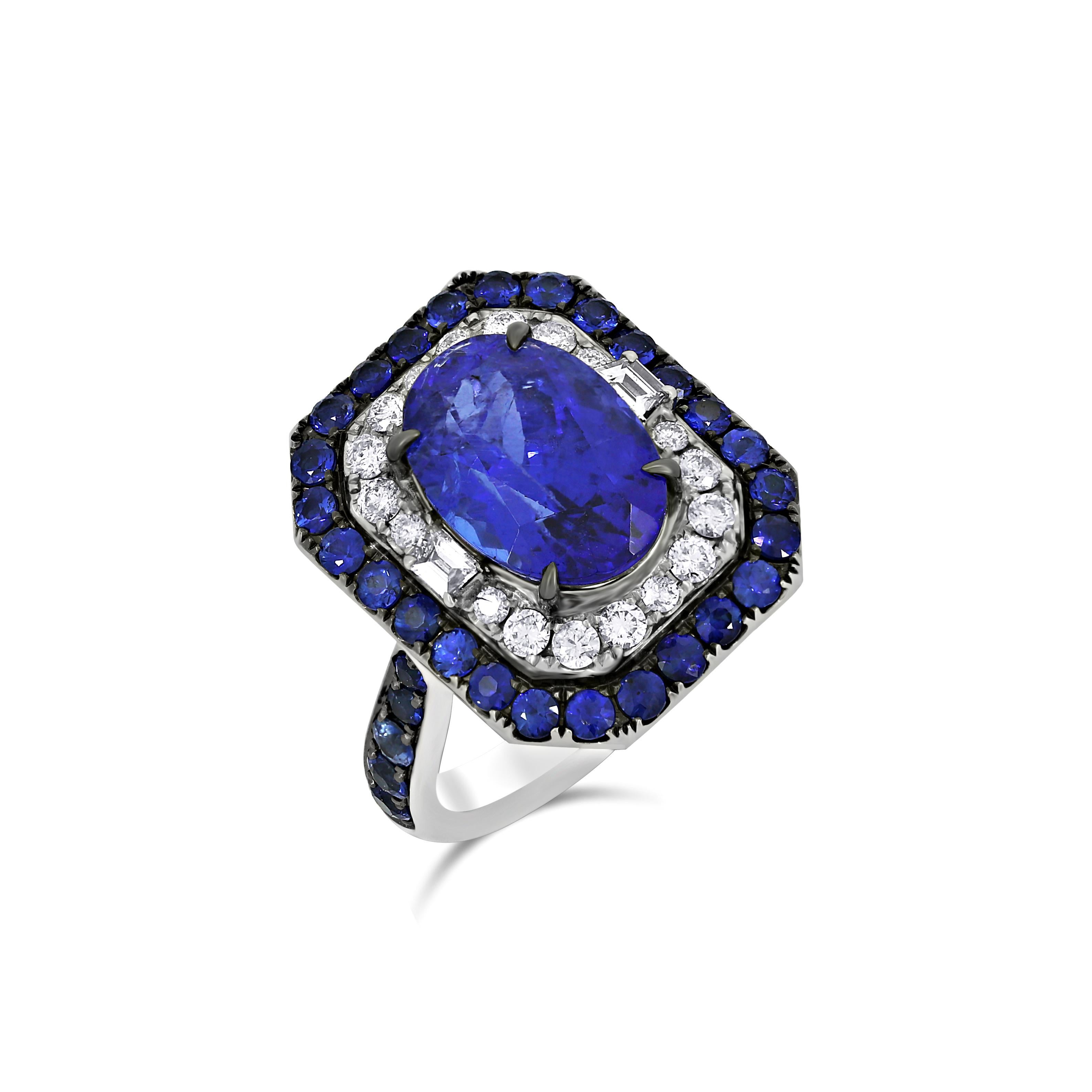 Introducing the exquisite Nigaam 7.13 Cttw. Tanzanite, Blue Sapphire, and Diamond Engagement Ring – a masterpiece that captures the essence of elegance and luxury. This remarkable ring is a symbol of timeless beauty, meticulously crafted to