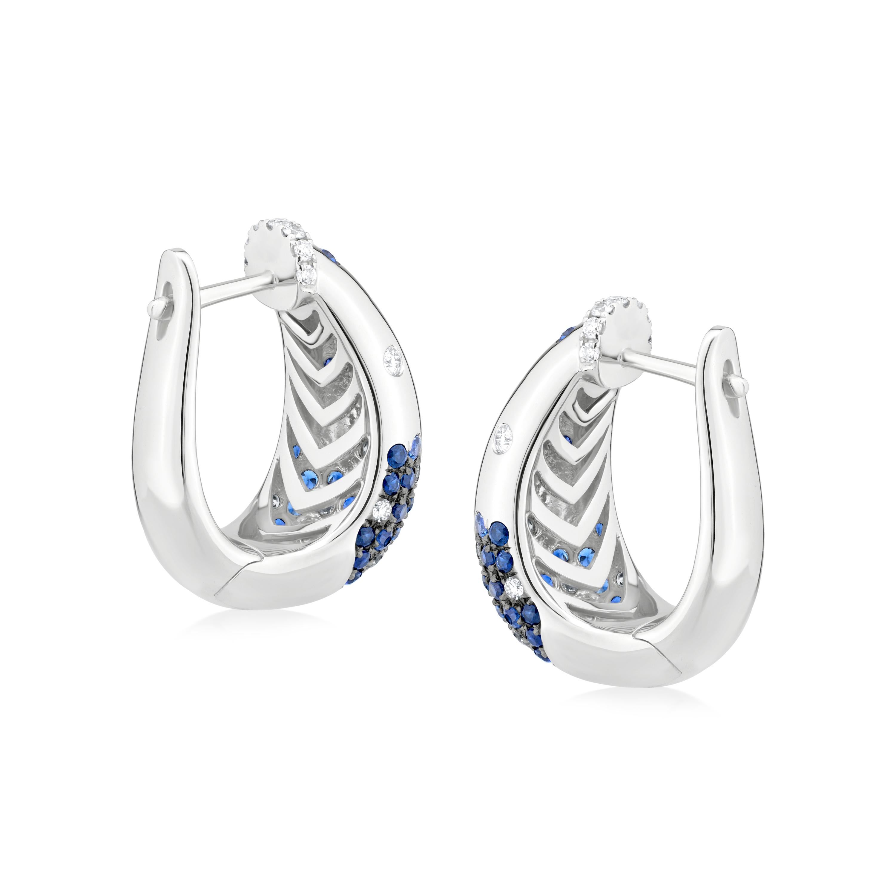 Aggiungi un tocco di colore vibrante e di scintillante eleganza al tuo look con questi orecchini a cerchio con zaffiro e diamante di Serpens. Realizzati in oro bianco lucido 18 carati, questi orecchini presentano un design contemporaneo a cerchio