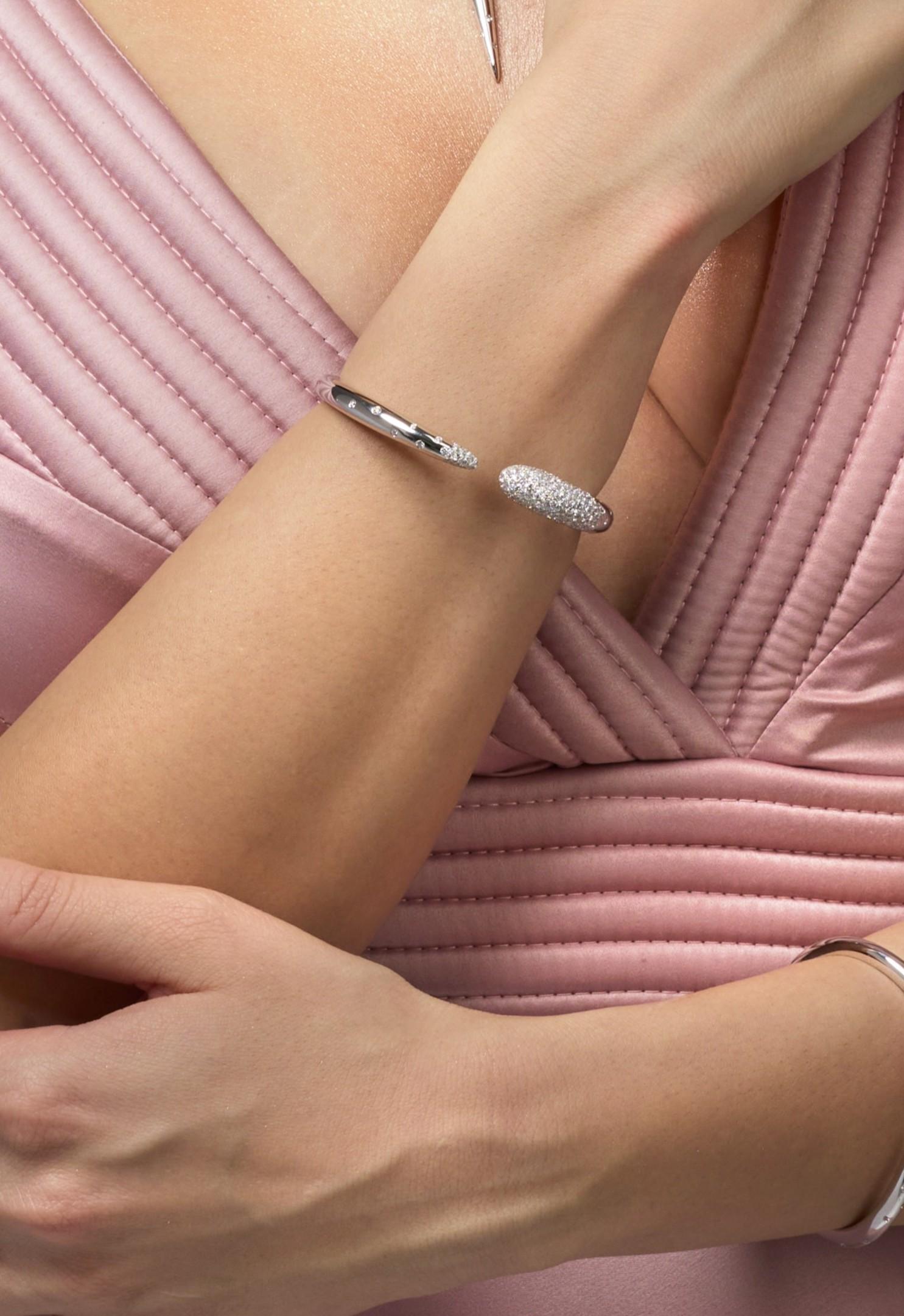 Umhüllen Sie Ihr Handgelenk mit himmlischer Eleganz mit dem Serpens Diamond Coil Bangle Bracelet. Dieser exquisite Armreif aus poliertem 18-karätigem Weißgold besticht durch sein offenes Spiral-Design, das sich anmutig um das Handgelenk legt.

Im