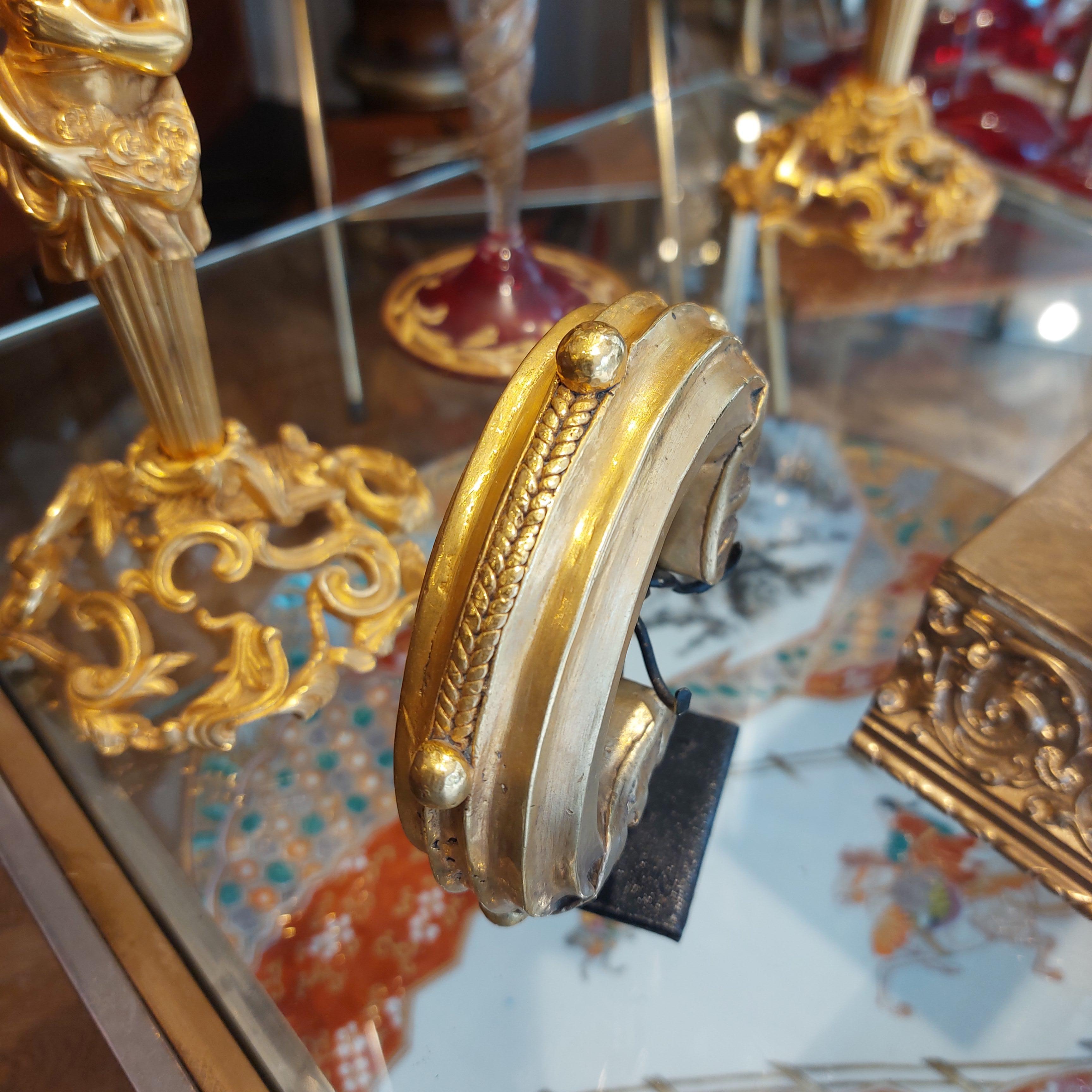 Ti presentiamo un antico braccialetto nigeriano del XIX secolo in bronzo placcato in oro di alta qualità, tradizionalmente utilizzato per funzioni monetarie e di scambio nella tribù e come ornamento del corpo per le donne. 

Il suo design unico e