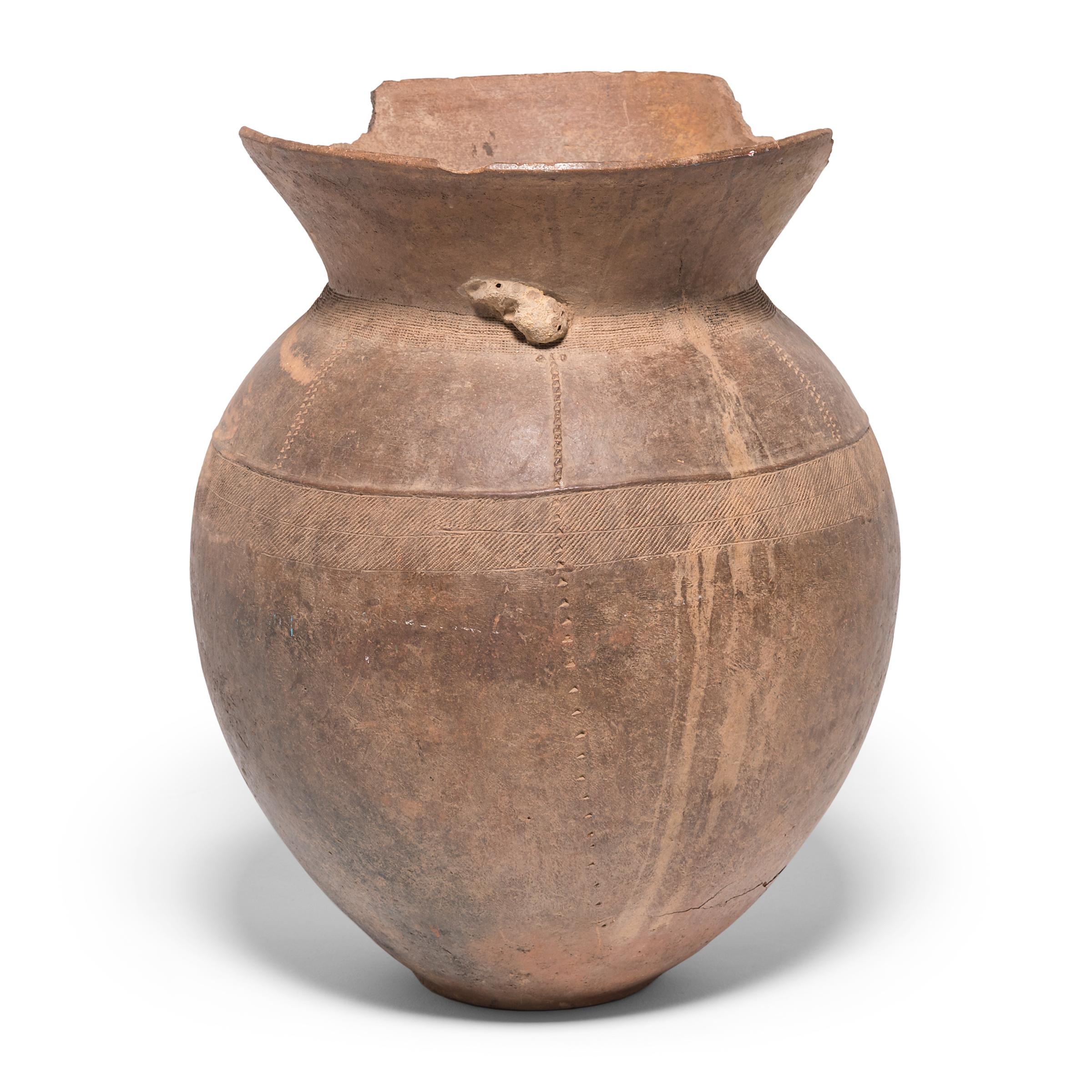 The Nupe people of Nigeria were known as some of the finest ceramicists in Africa. Everyday objects, like this storage vessel, received detailed attention. Likely used to hold grain and other dry foods, the vessel's varied textures come from its