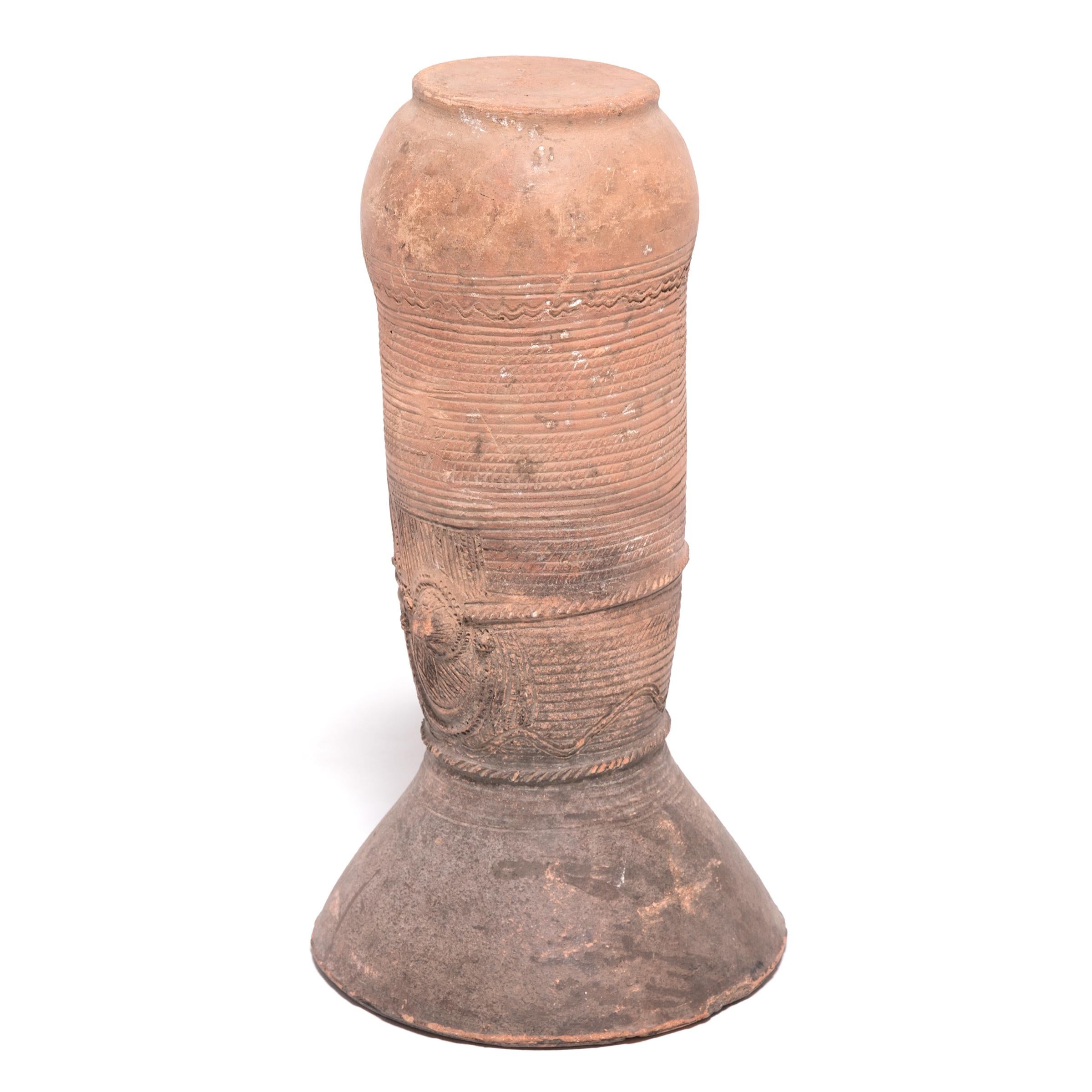 The Nupe people of Nigeria were touted as some of the finest ceramicists in Africa. Everyday objects, like this elegant, cylindrical vessel support, received detailed attention. This flaring terra cotta form would have been buried halfway in the