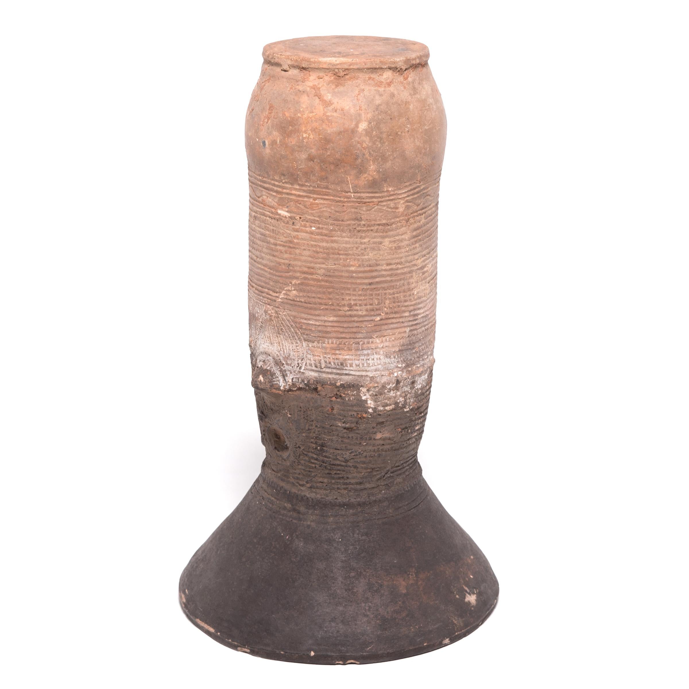 The Nupe people of Nigeria were touted as some of the finest ceramicists in Africa. Everyday objects like this elegant, cylindrical vessel support received detailed attention. This flaring terracotta form would have been buried halfway in the ground