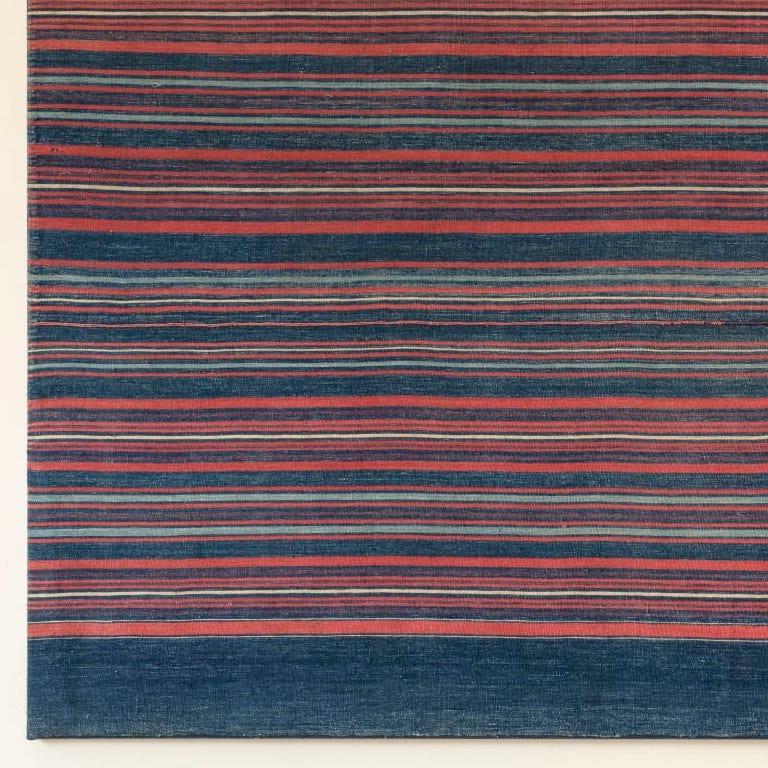 A very unusual cloth woven in shades of blue with coral and ivory stripes.
This type of cloth is woven to celebrate the coming of age of girls in the village.
Conservation mounted on a stretcher.
Ososo Village. Edo, Nigeria 1930s
H 86 x W 145cm