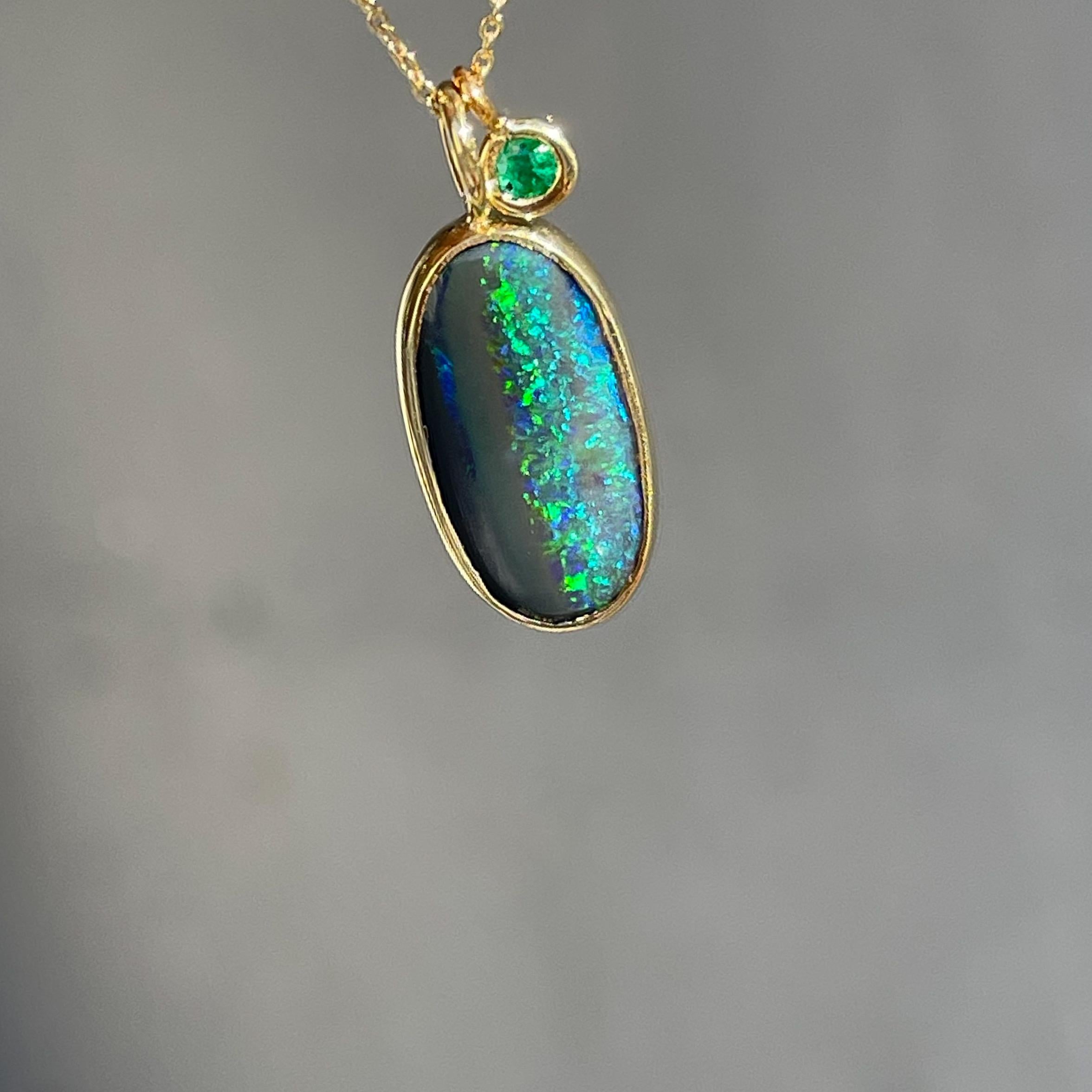 A striking black opal channels time in the Night Becomes Her Emerald and Opal Necklace. Oval in shape, the lightning ridge opal is black on one side and emerald green on the other — the split pattern reminiscent of a revolving moon, part in shadow.