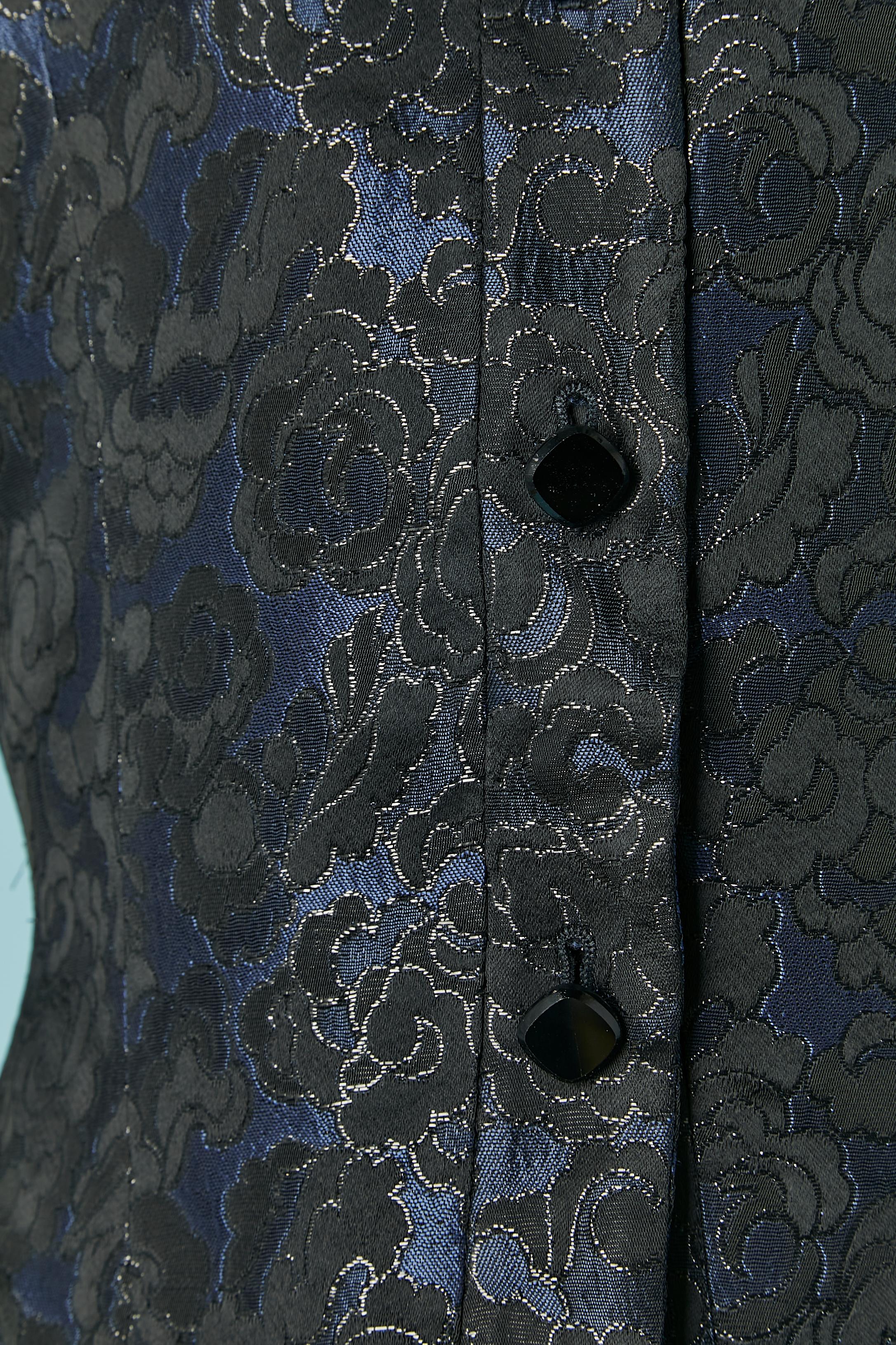 Gonna-tuta in damasco blu notte, nero e lurex.
Composizione della Fabrice: 63% acetato, 29% rayon, 8% poliestere. Composizione della fodera: 60% acetato, 40% cupro 
Maniche raglan. Taglio e lavorazione. 
TAGLIA 38 (Fr) 8 (Us) 10 (UK) 