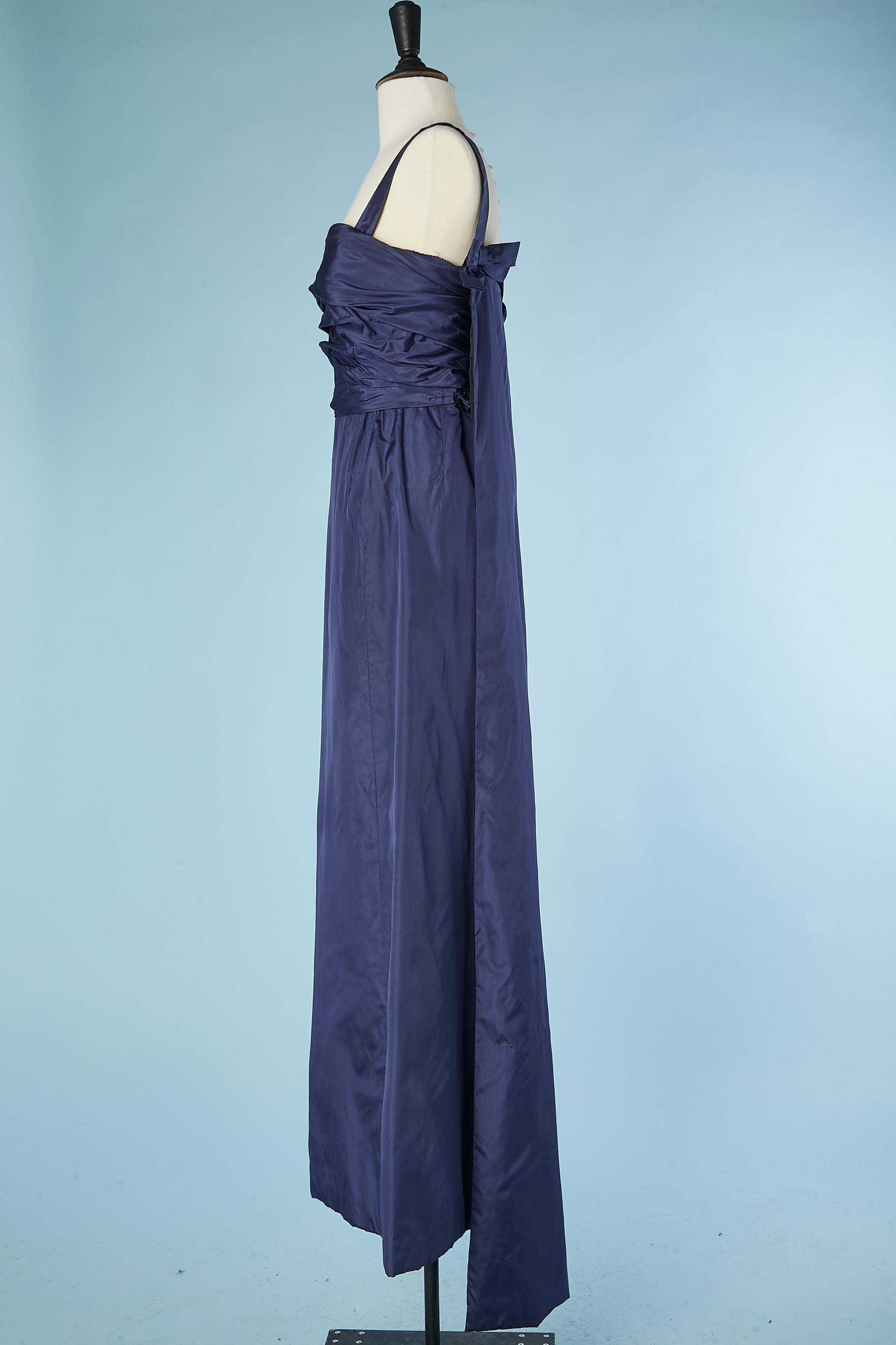 Night blue taffetas evening dress. Draped on the bust and waist. 2 taffetas bow on the back with a drag in the same fabric. Snap, hook&eye and snap ( covered with fabric) to close the dress in the middle back and side. Boned bustier underneath the