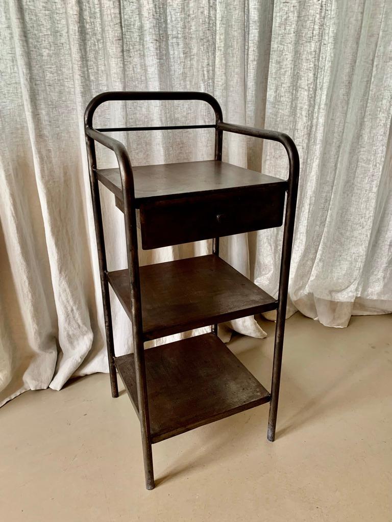 Vintage French metal night stand or side table with the greatest patina in the raw metal. The night stand has one drawer and 2 shelves.
