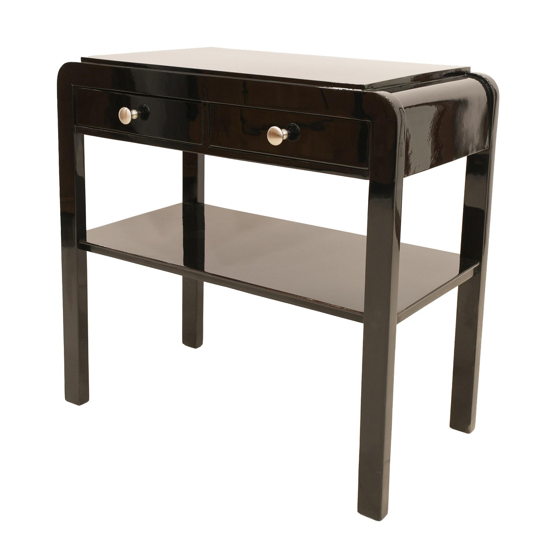 This elegant nightstand comes from Poland from early 20th century. It was renovated, finished with piano lacquer and polished to a high gloss. The table features 2 practical drawers and a shelf.