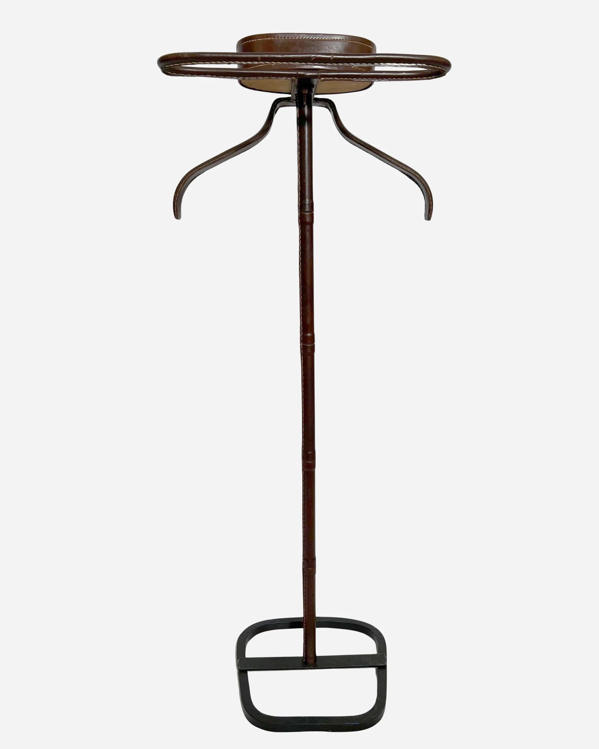 Wrought-iron dumbwaiter, the stem, basket and garment-holding part covered in tan leather with saddle-stitching, the lower shoe-holding part painted black.

Biography

Jacques Adnet, France (1900-1984)

Jacques Adnet is a talented French architect,